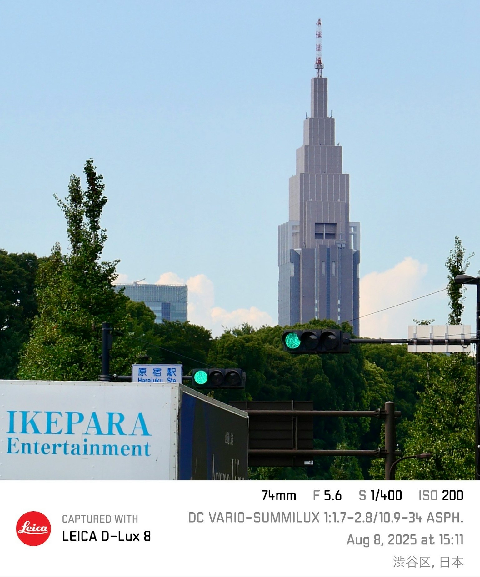 Vue d'un gratte-ciel de Shinjuku avec une verdure luxuriante et un panneau de divertissement