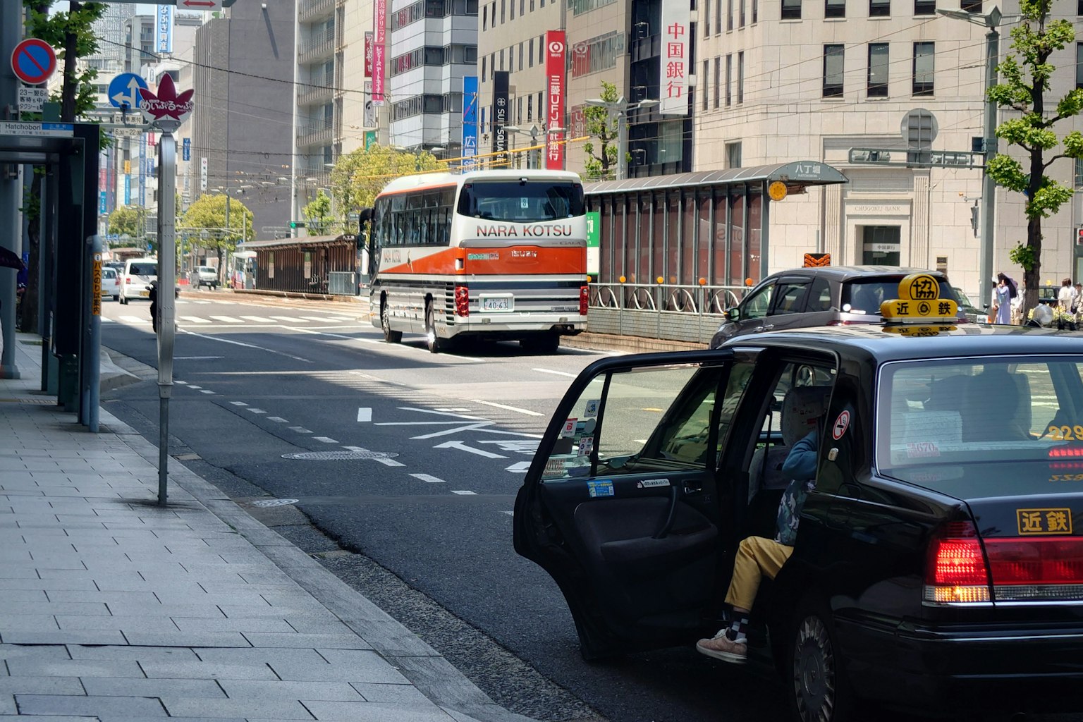 Escena de una calle de la ciudad con un taxi estacionado y un autobús