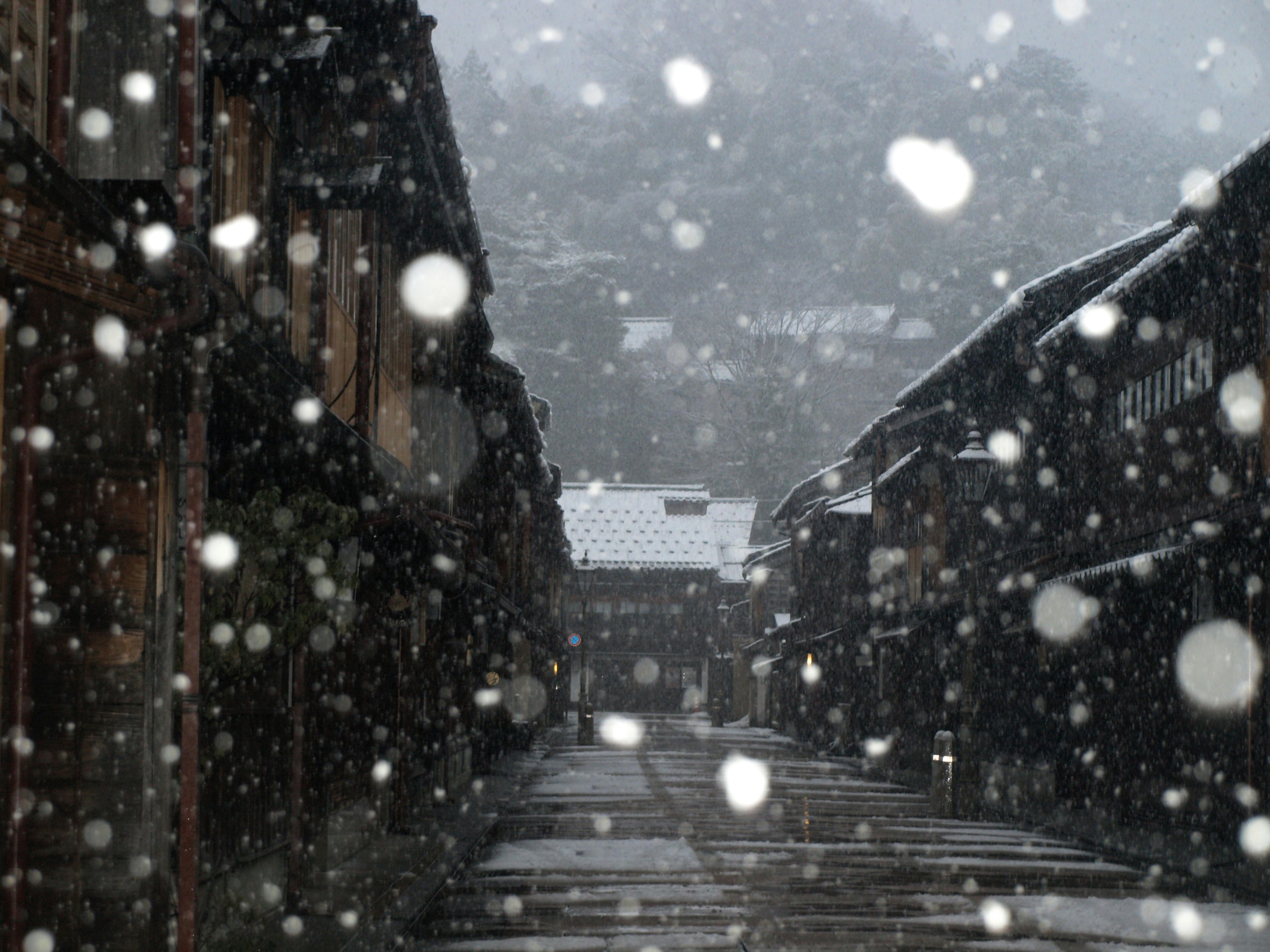 雪の降る石畳の路地と階段のある街並み