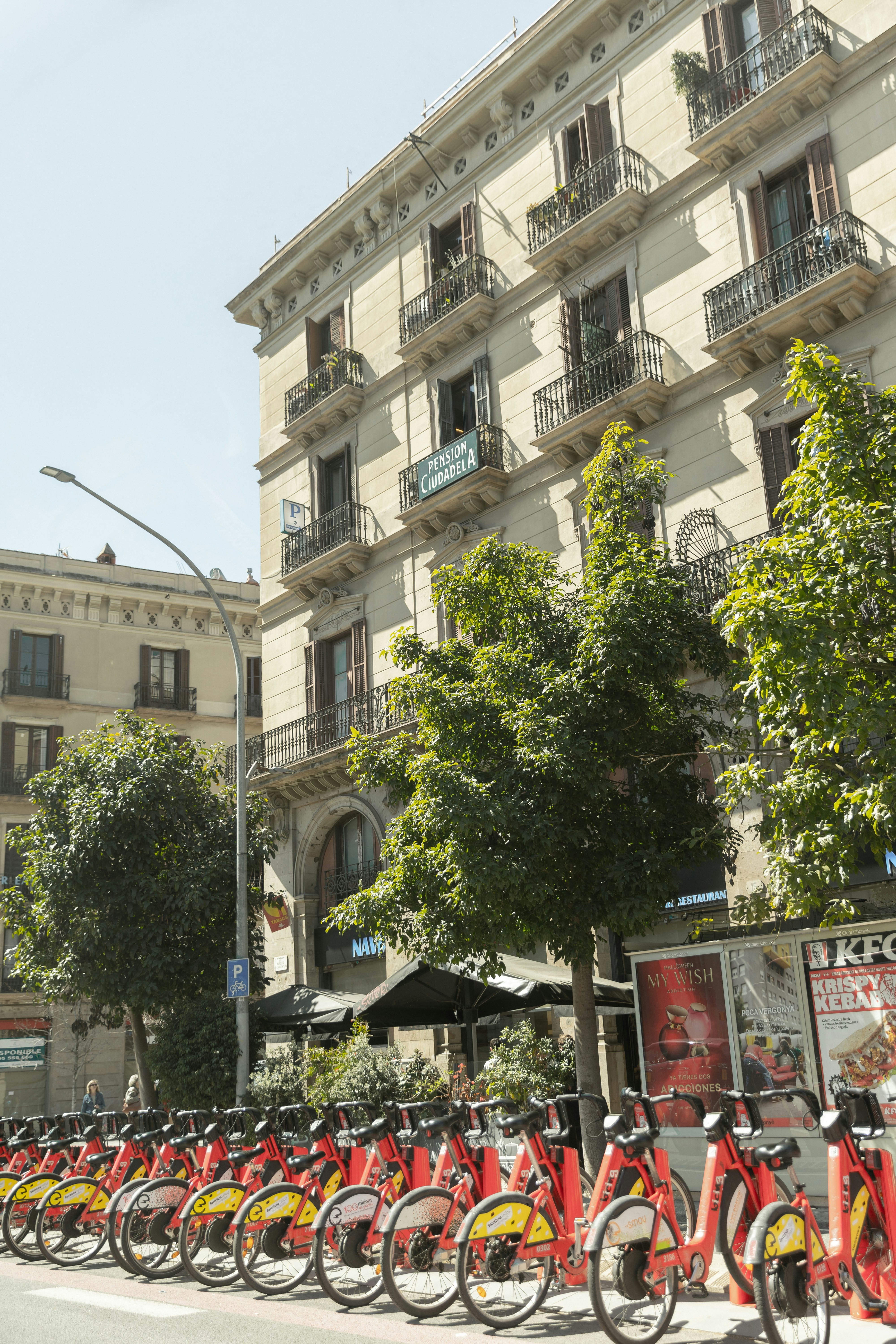 Vélos rouges alignés dans une rue de Barcelone avec des façades d’immeubles