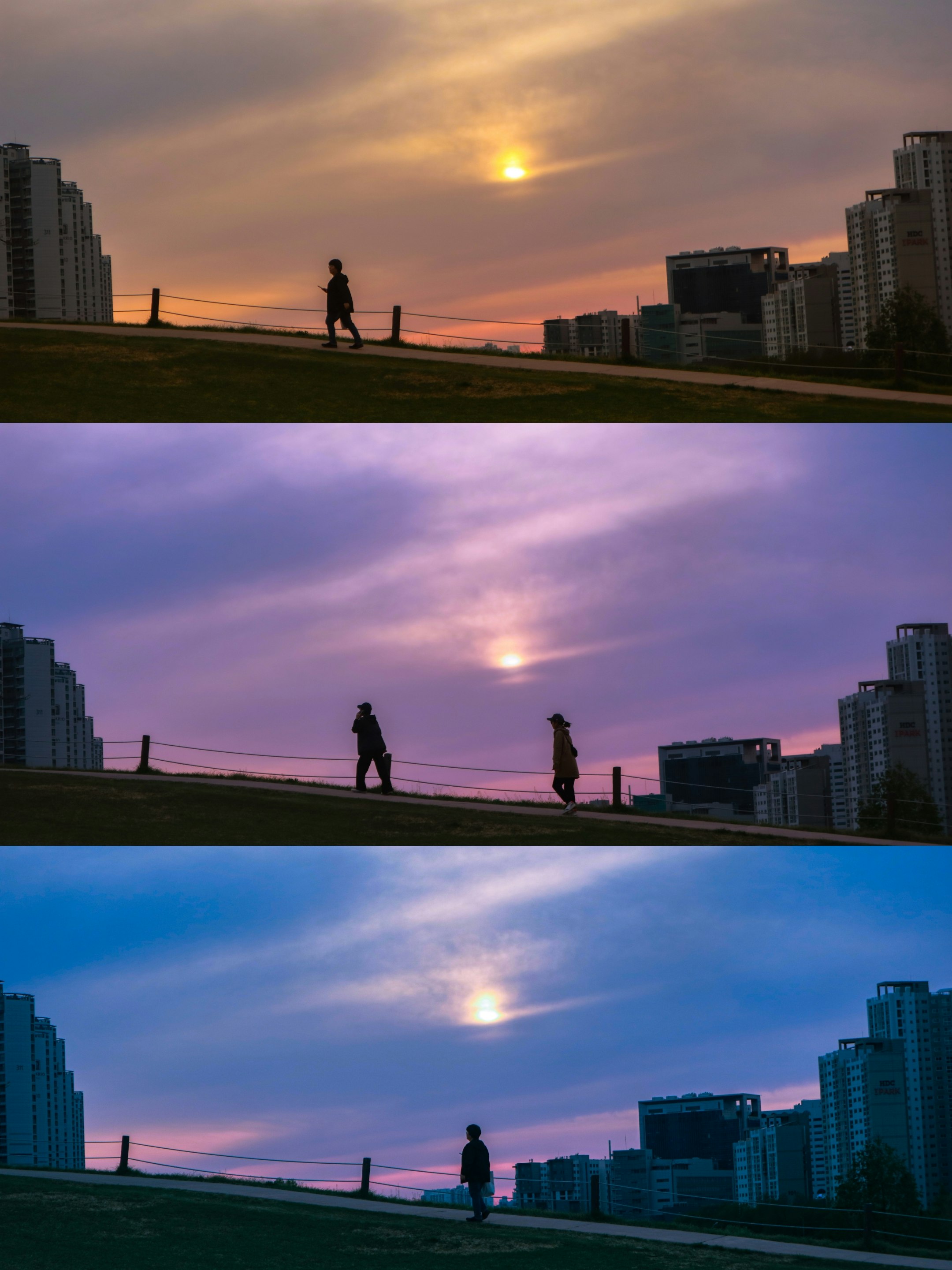 夕暮れの空と川沿いの遊歩道を歩く人々のシルエット