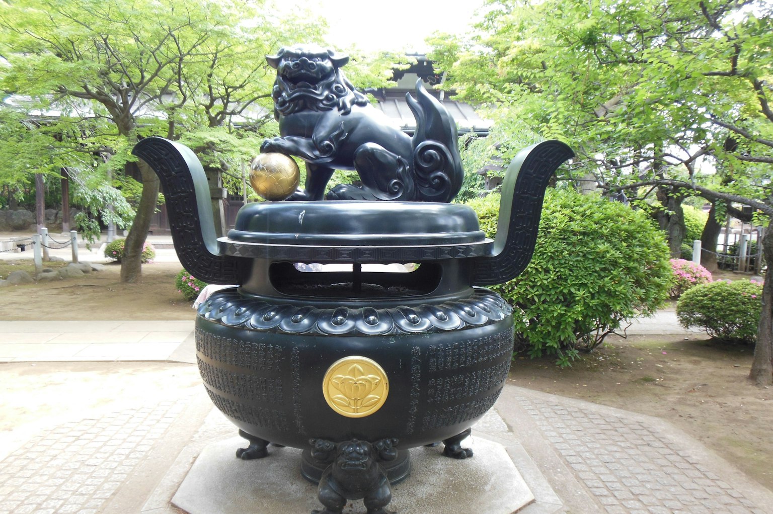 A black incense burner featuring a lion sculpture on top