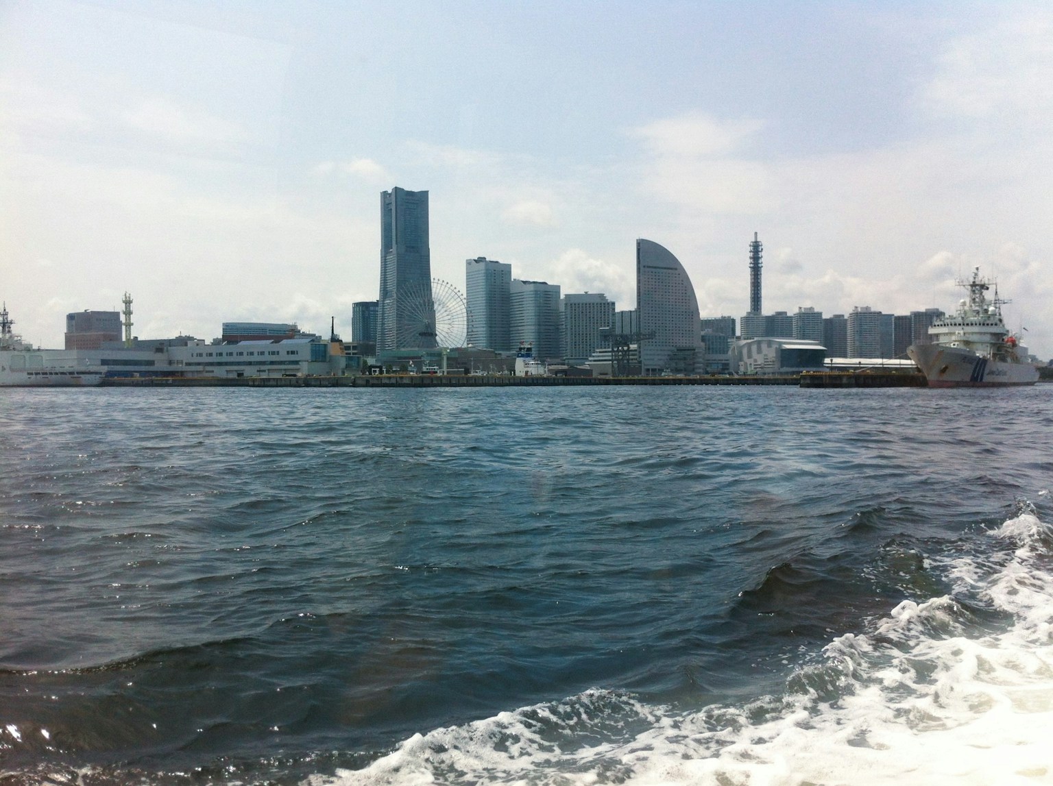 ทิวทัศน์ของเส้นขอบฟ้าของโยโกฮาม่าพร้อมอาคารสมัยใหม่และท่าเรือจากทะเล