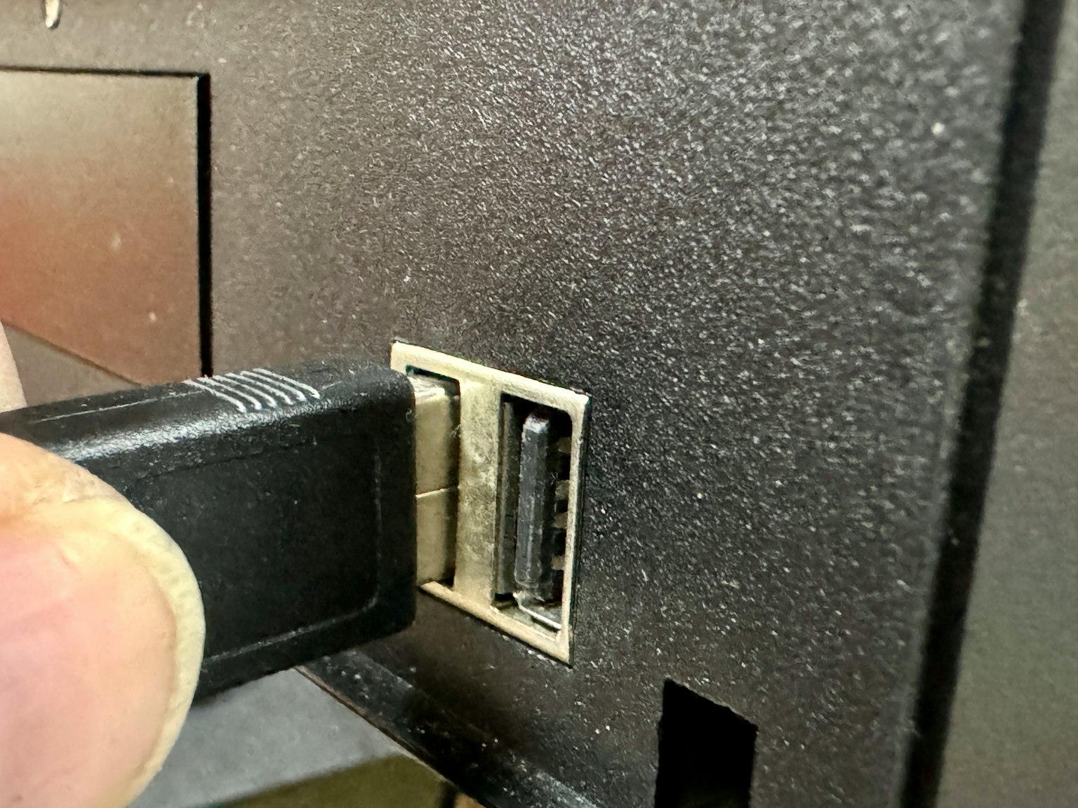 Một đầu nối USB đang được cắm vào cổng USB của máy tính