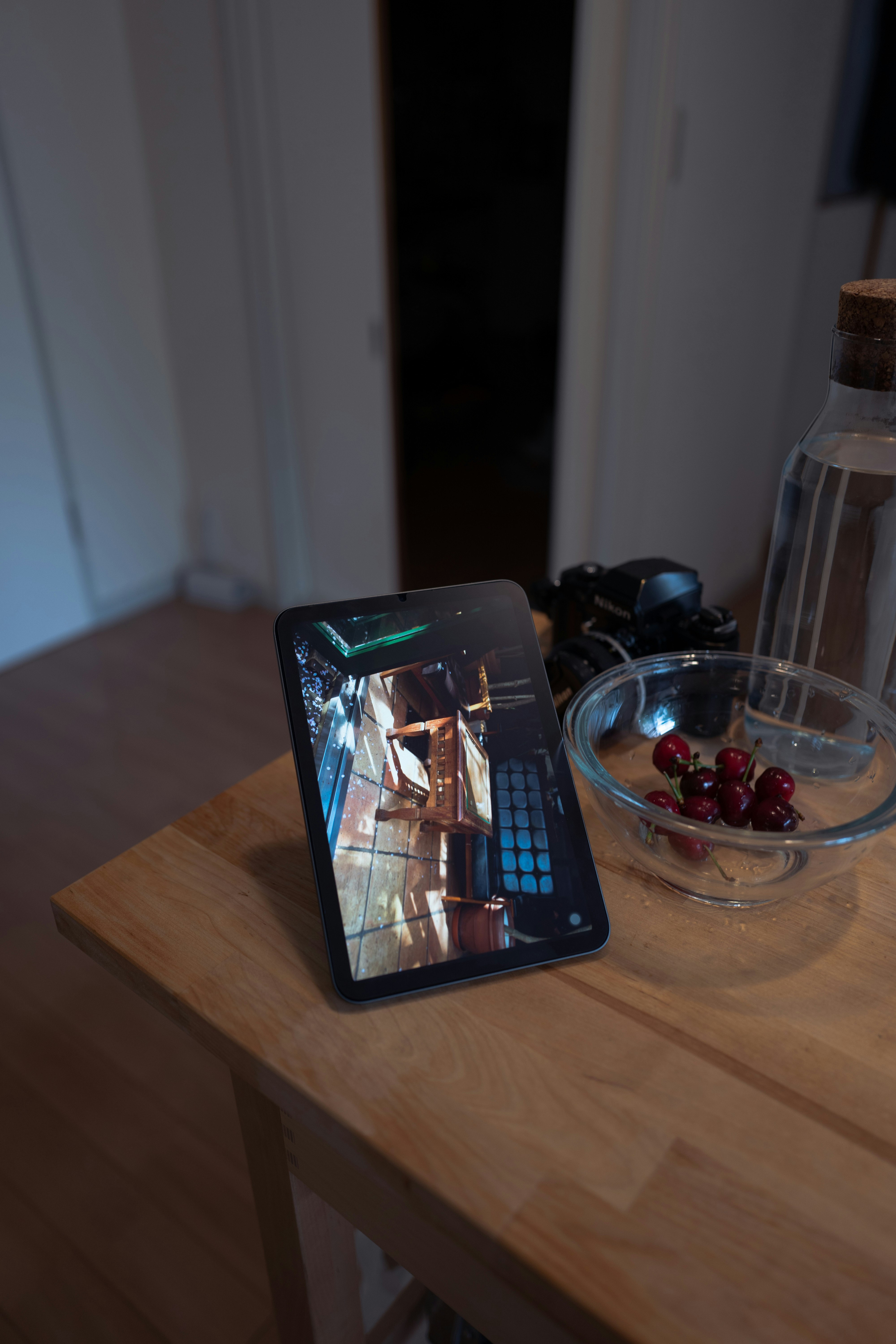 木の机の上に置かれたタブレットとガラス容器