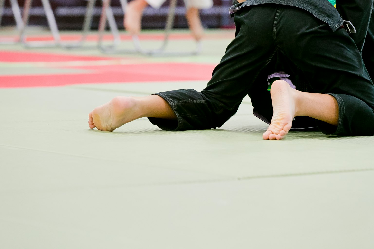 Piedi di un bambino e parte del corpo su un tappeto da judo