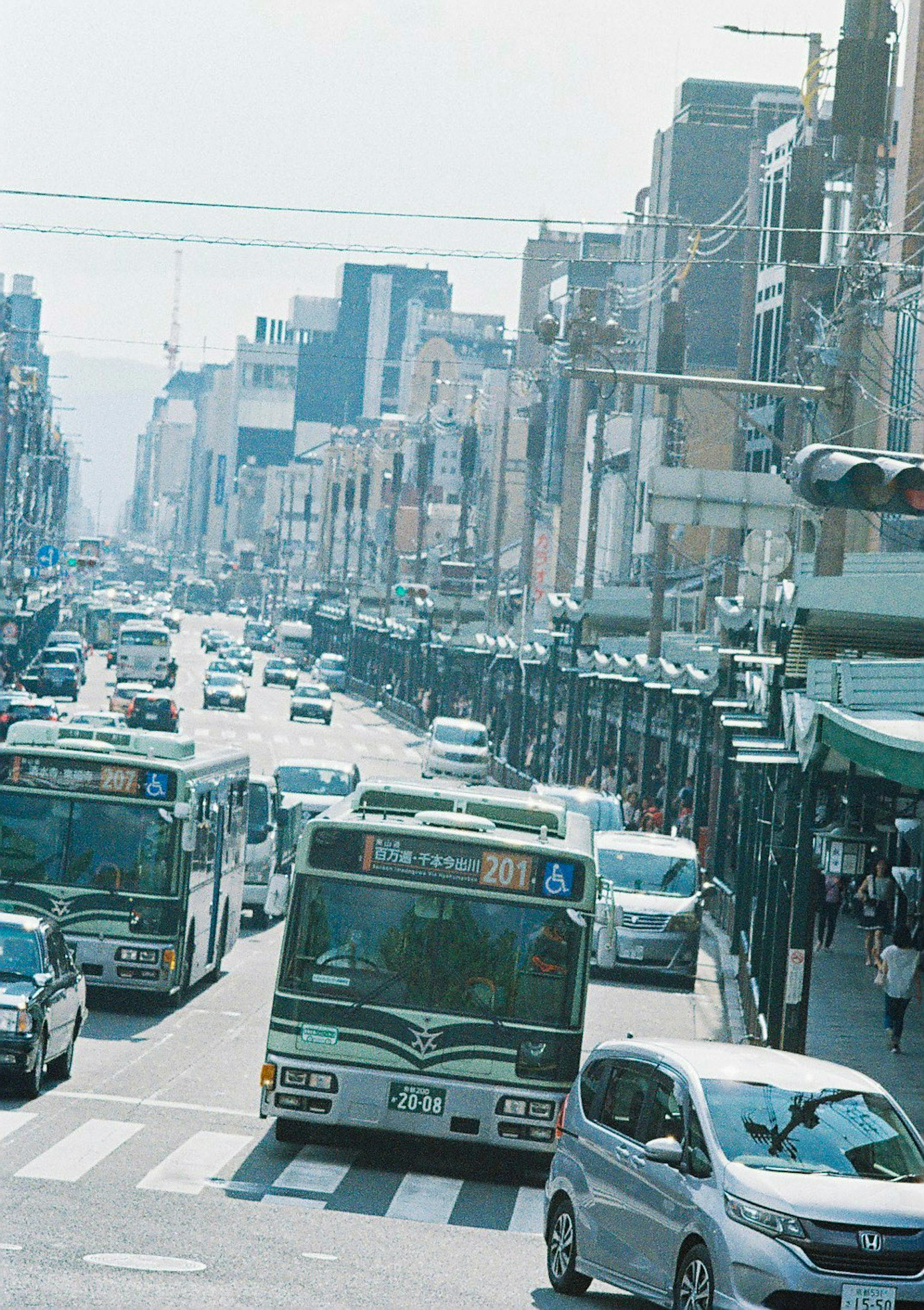 Belebte Straßenszene mit Bussen und Autos im Verkehr