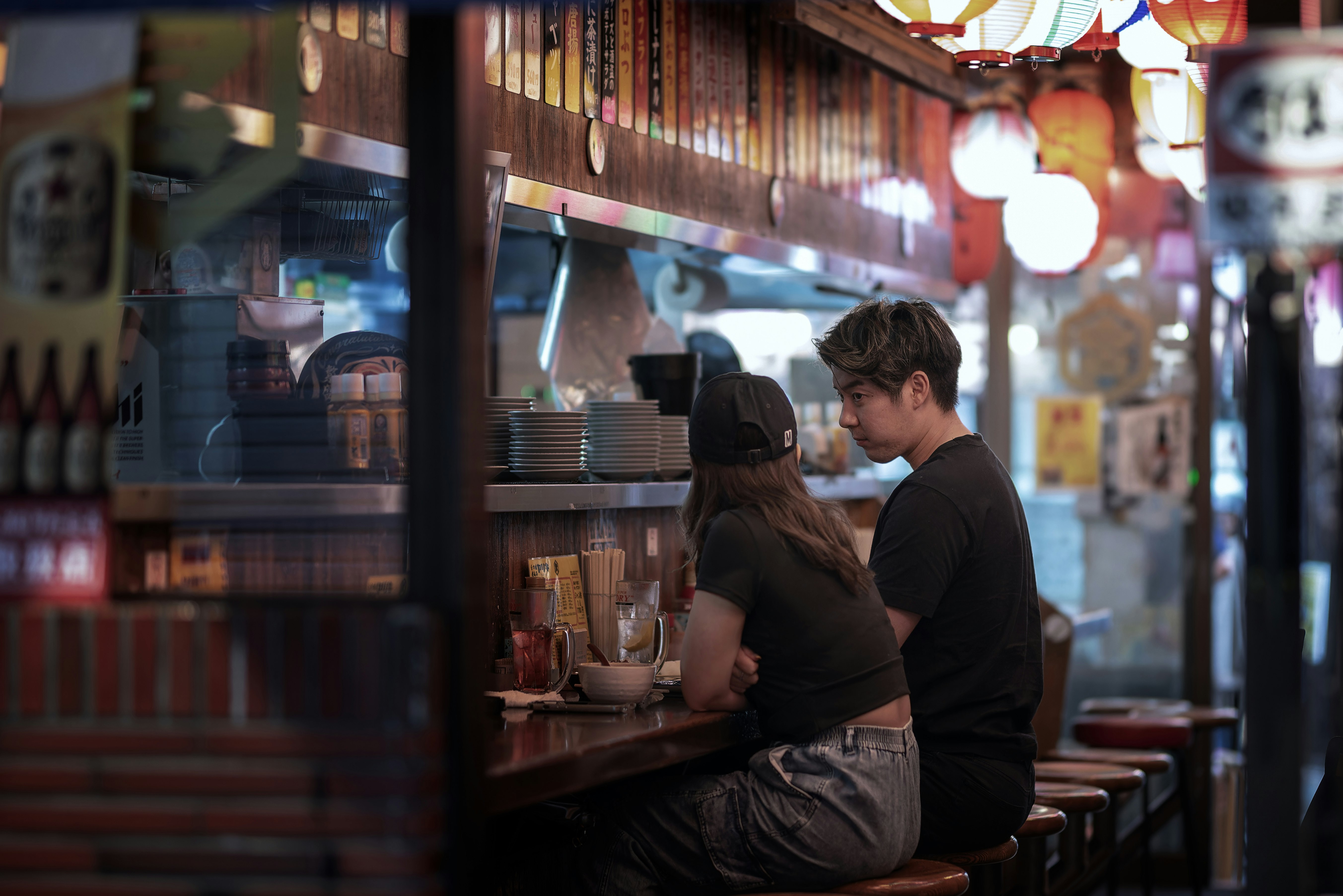 路地の小さな店内で棚の前にいる男女
