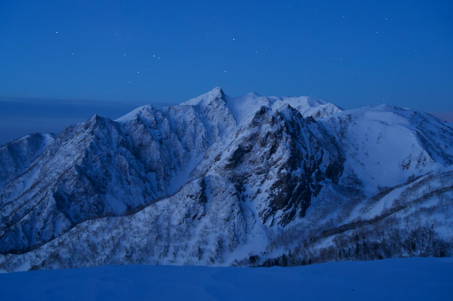 Gunung bersalju di bawah langit malam biru