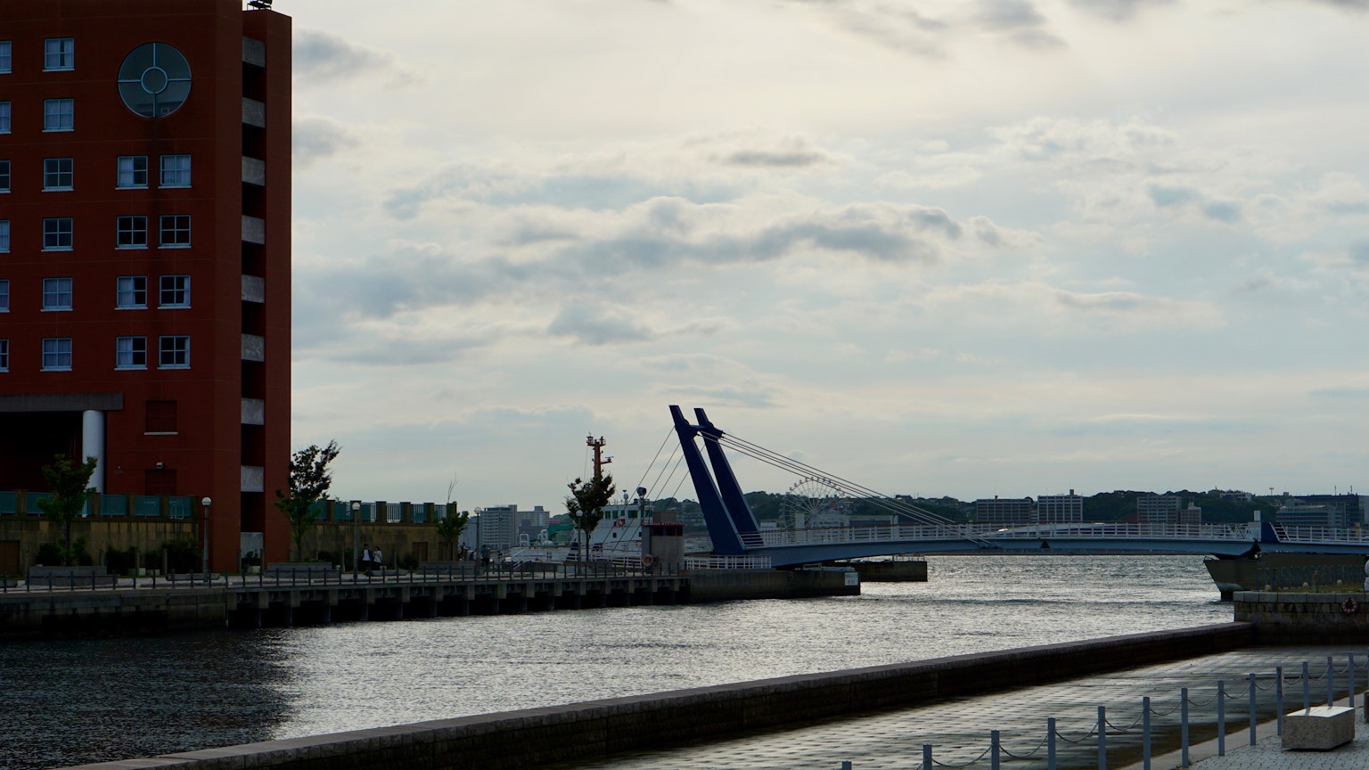 Rotes Gebäude am Fluss mit einer sich öffnenden Brücke
