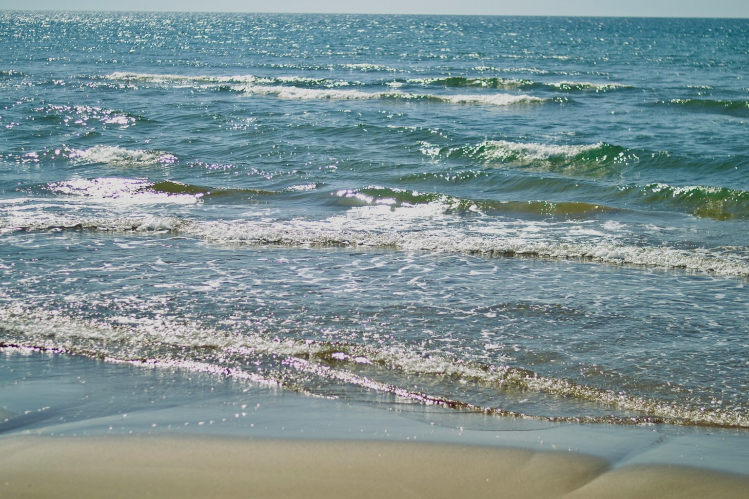 Calm ocean waves with a blue sky