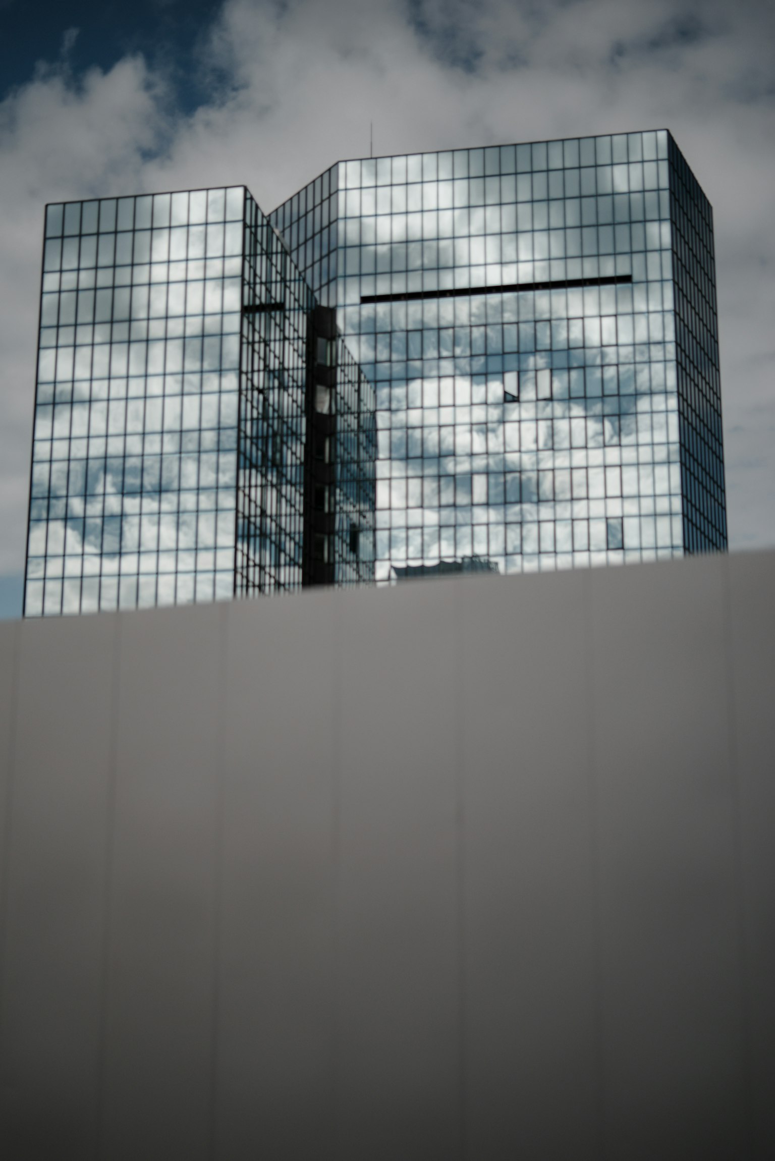 高层建筑的反光玻璃外观，天空中有云