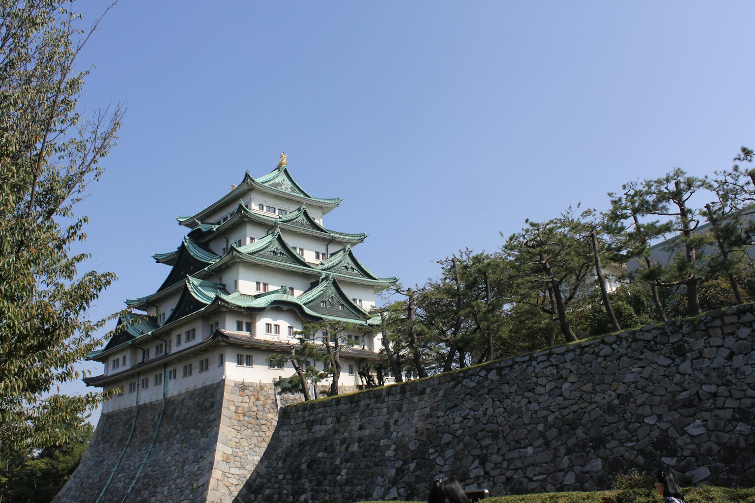 Die schöne Fassade von Nagoya Castle mit grünen Dächern unter einem blauen Himmel