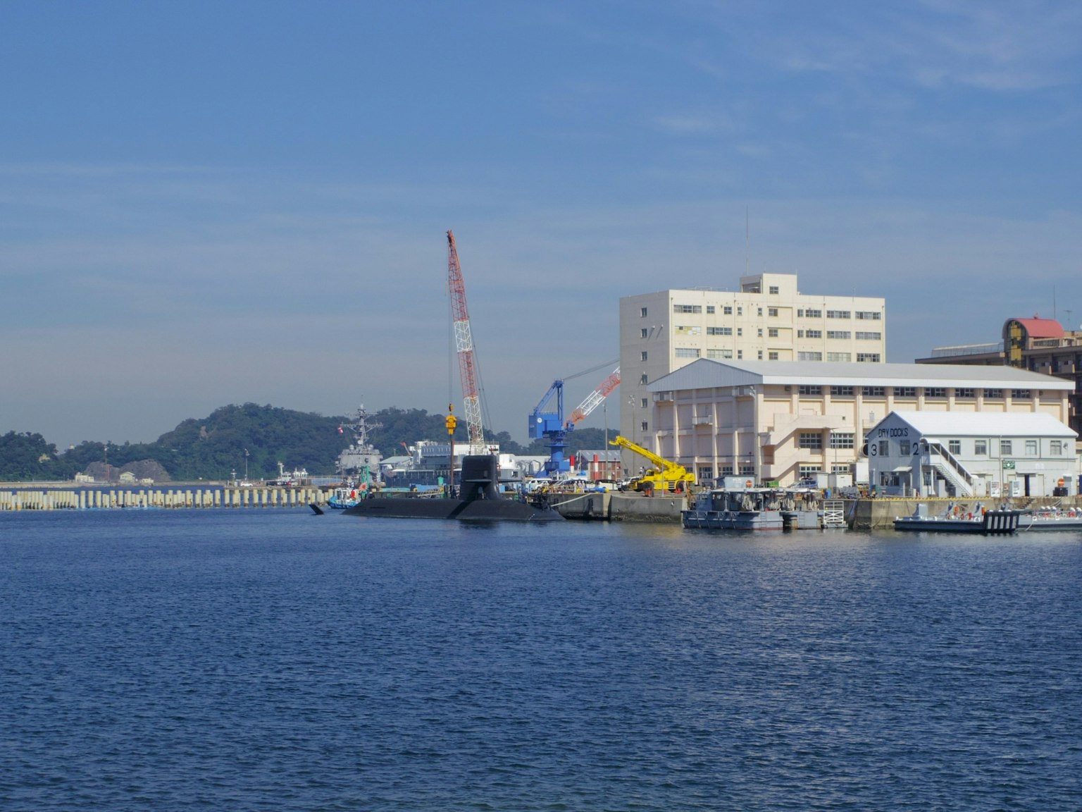 Malersicher Blick auf einen Hafen mit blauem Wasser Kränen und Gebäuden