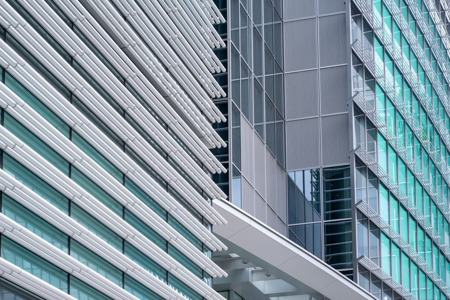 Extérieur d'un bâtiment moderne avec façade en verre rayé et métal