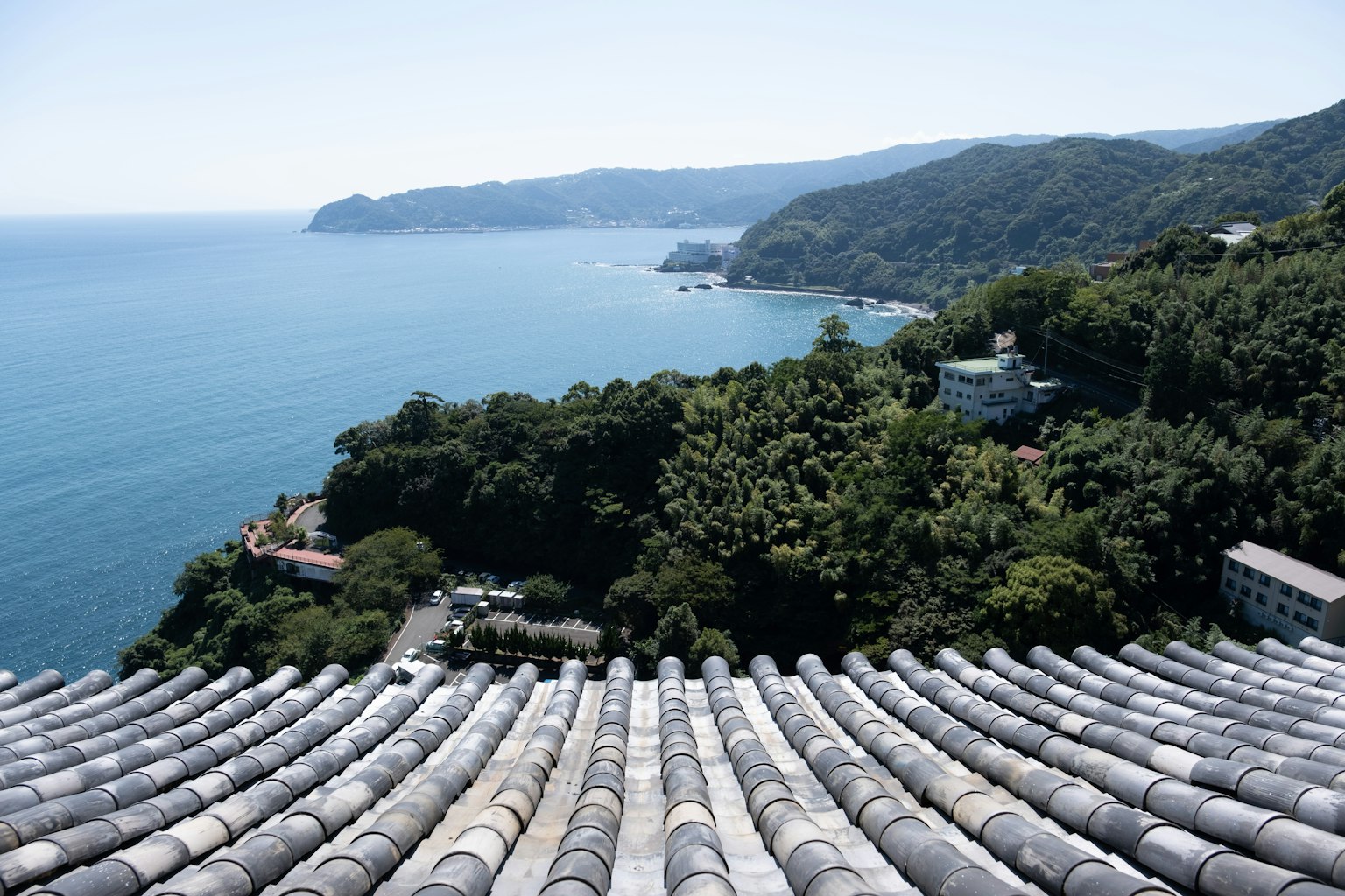 Paysage magnifique de la mer et des montagnes vue d'un toit en tuiles