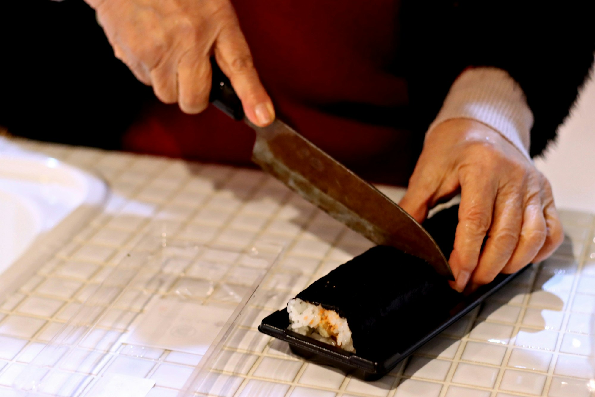 mani che preparano il sushi con un tappetino