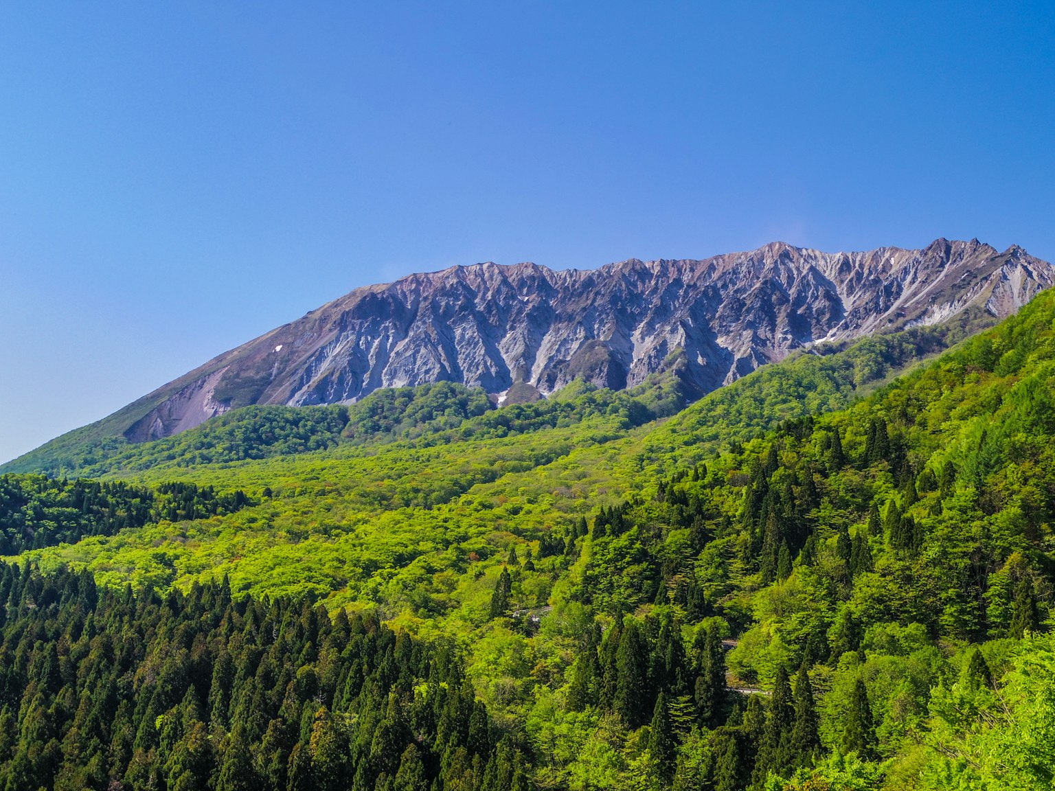 Montagne verdi sotto un cielo blu chiaro