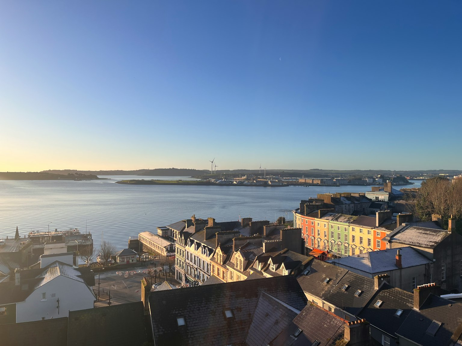 Vista panoramica di una città con edifici colorati e un mare calmo