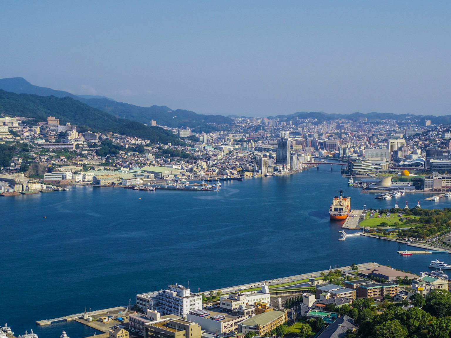 A panoramic view of Nagasaki harbor with mountains in the background