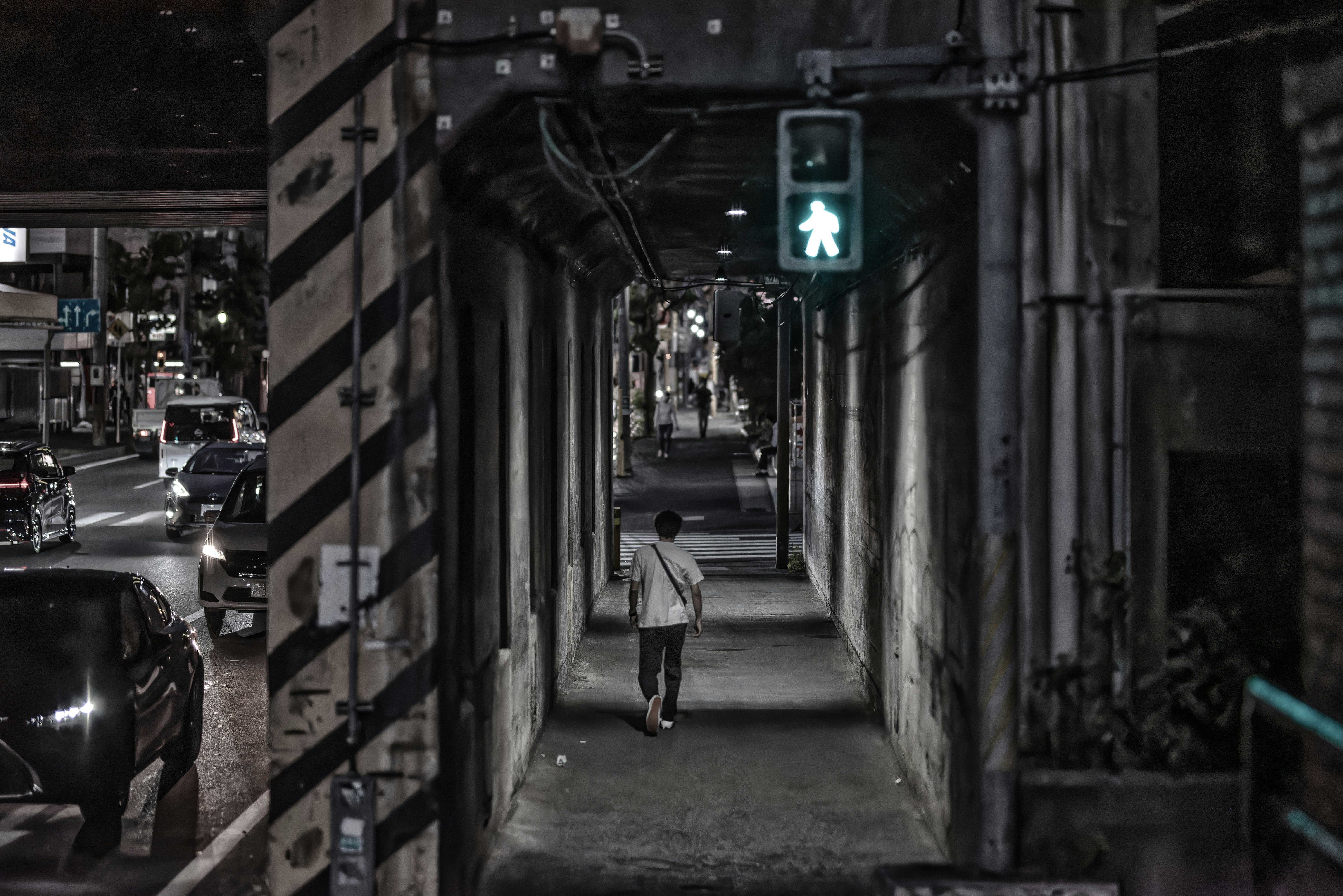 night alleyway receding into the distance with a person walking
