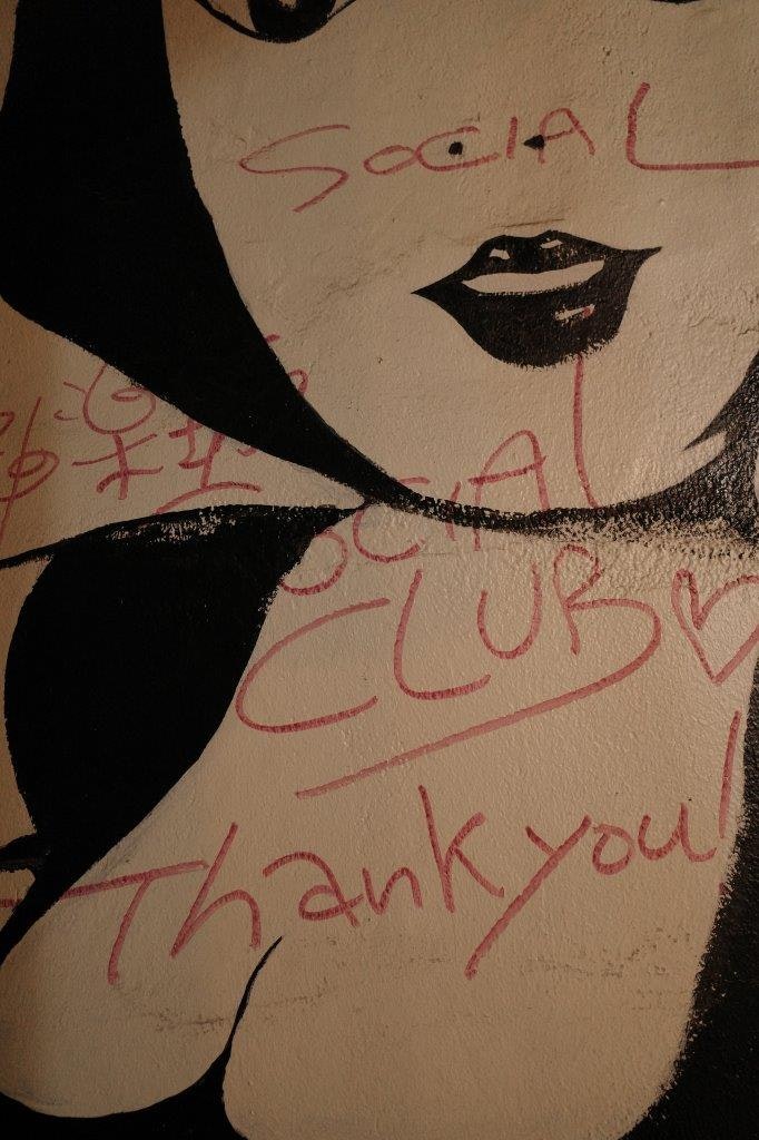 graffiti sur un mur avec une bouche peinte et du texte rouge