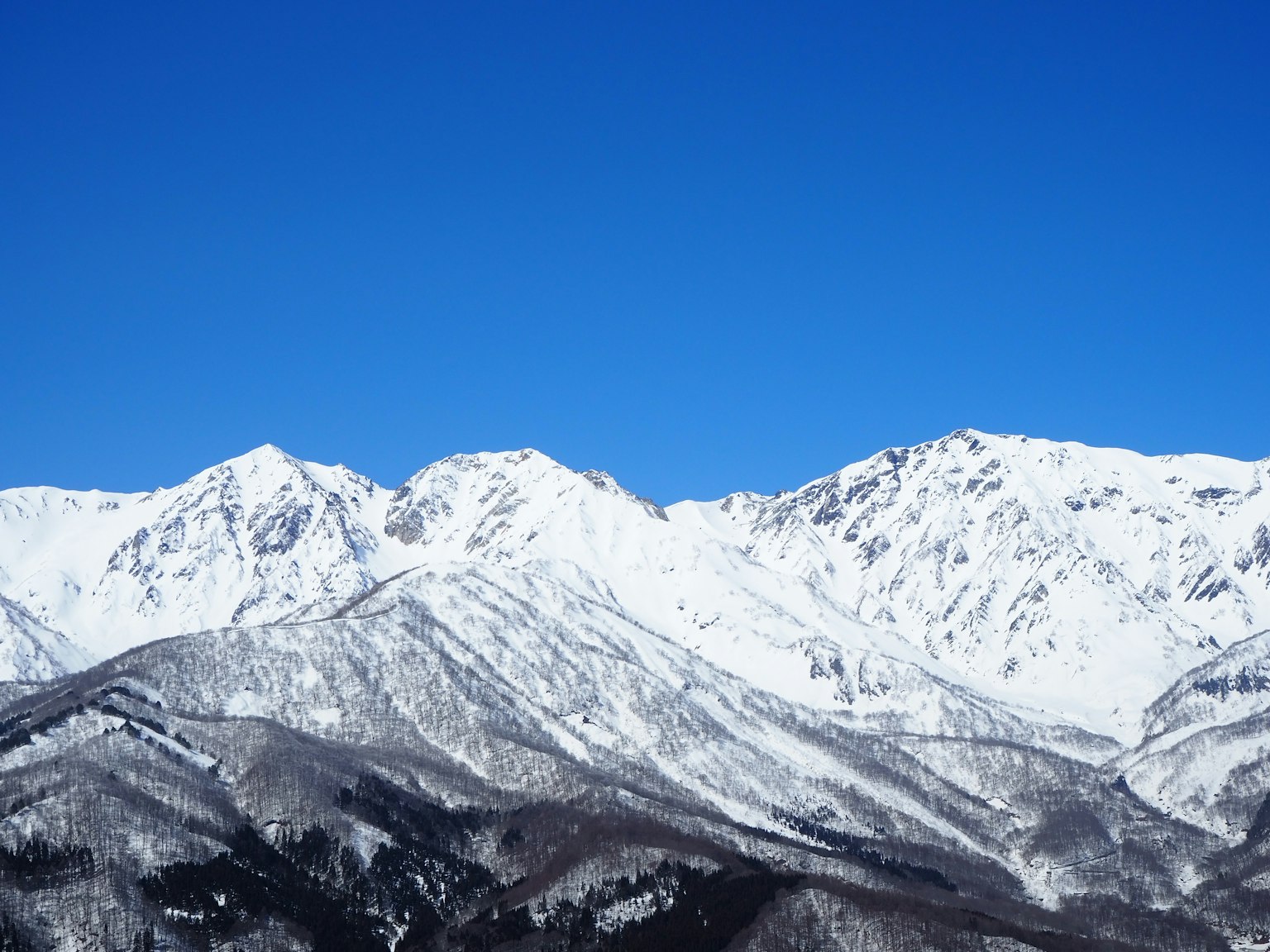 Montagne innevate sotto un cielo blu chiaro