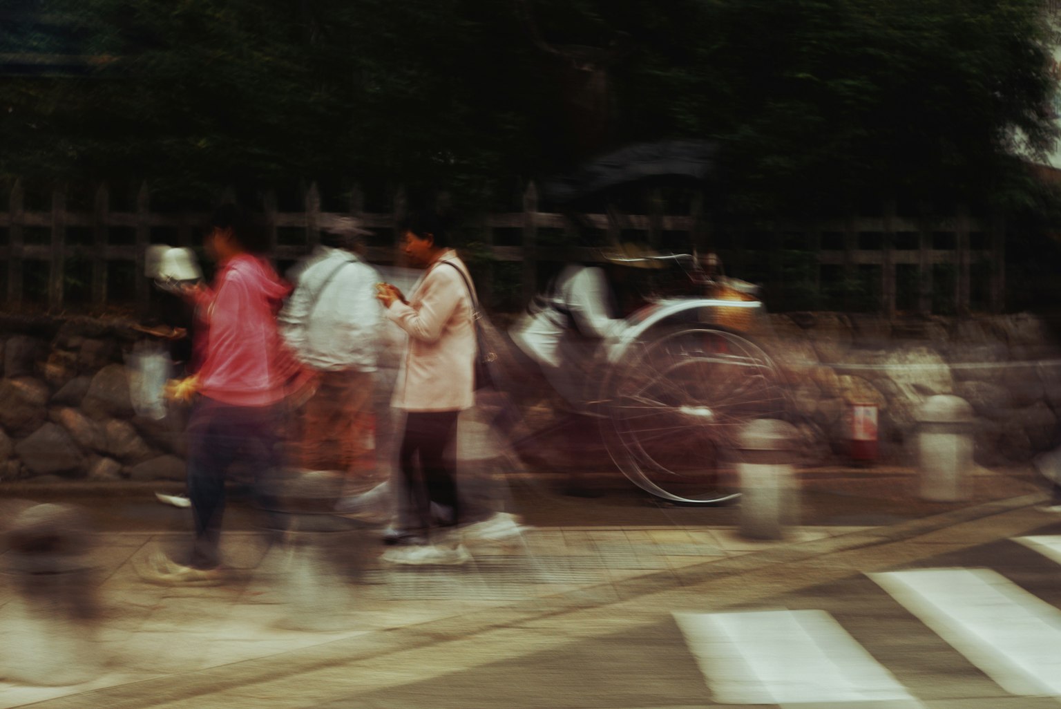 Blurred street scene with pedestrians and a rickshaw