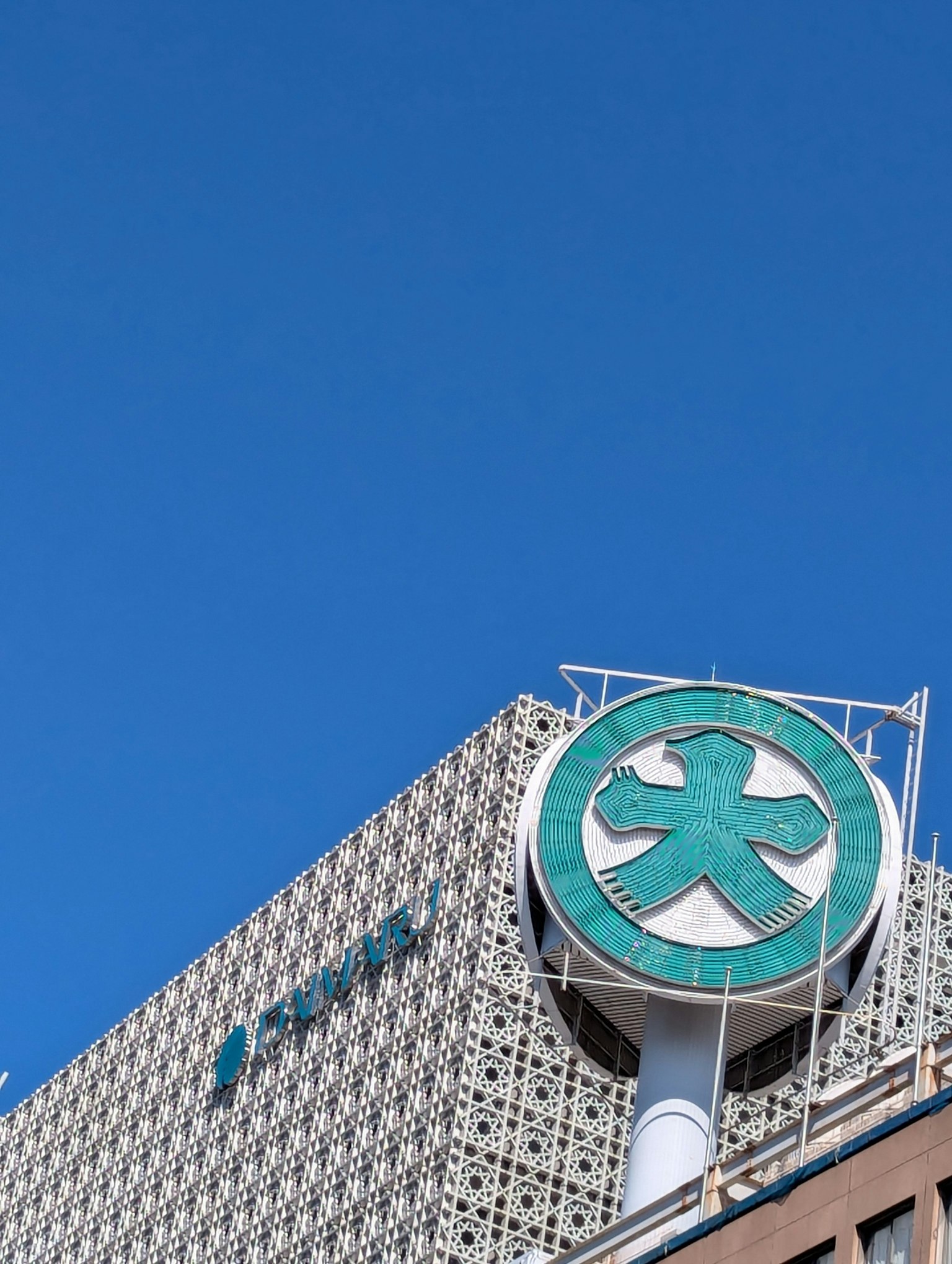 Building with a green symbol under a blue sky