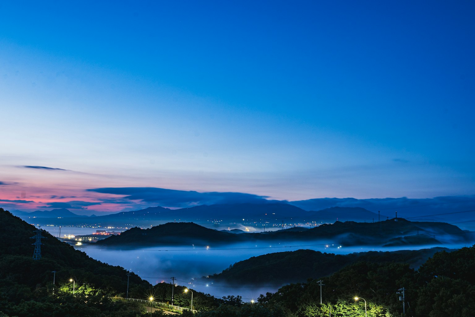 Schöne Landschaft von Bergen und Tälern, die im Zwielicht in Nebel gehüllt sind