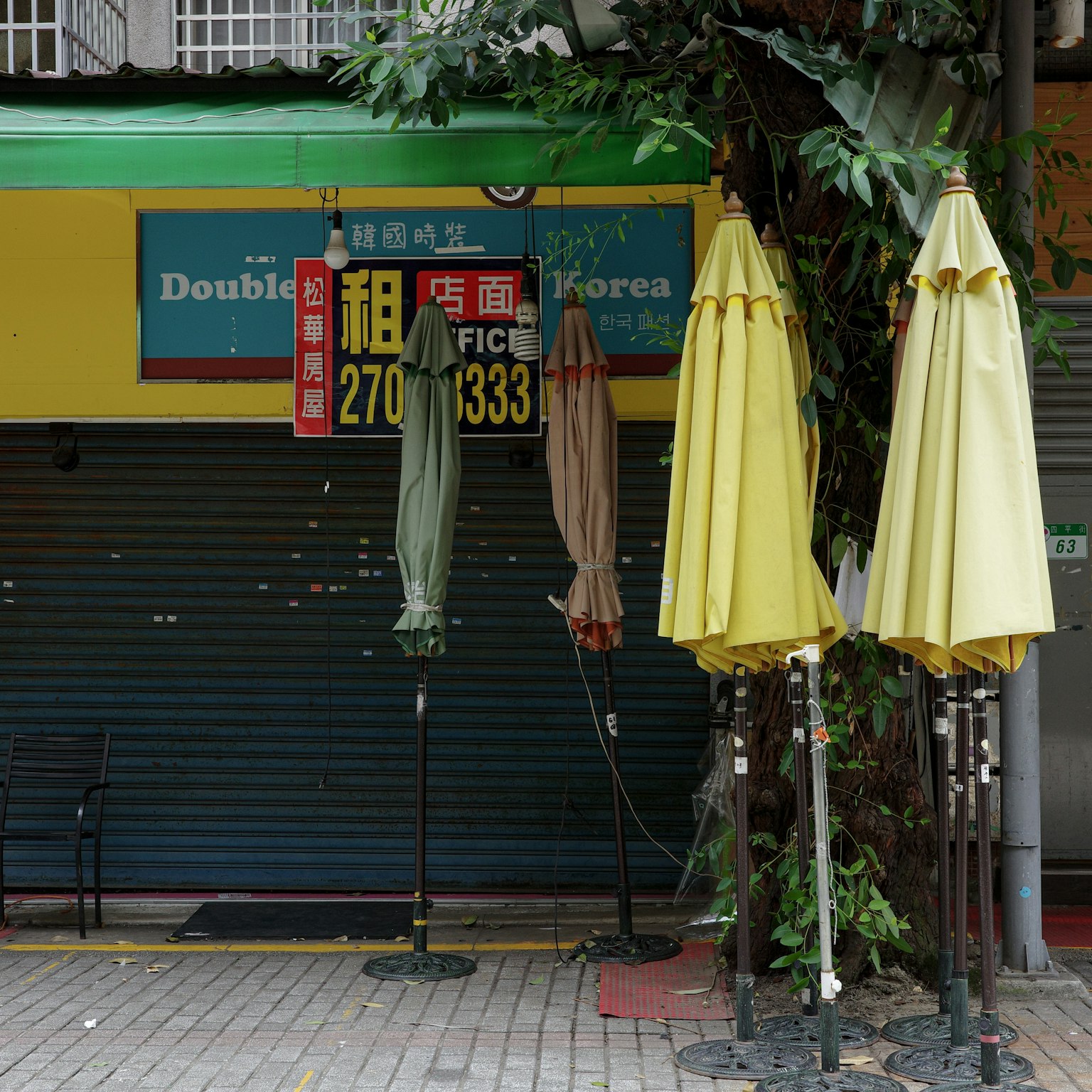 Una escena con paraguas frente a una tienda cerrada