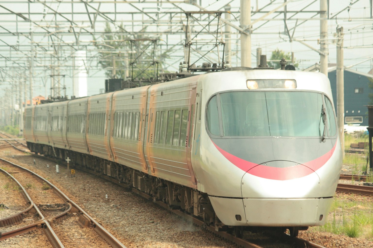รถไฟสีเงินที่มีเส้นสีแดงวิ่งบนราง