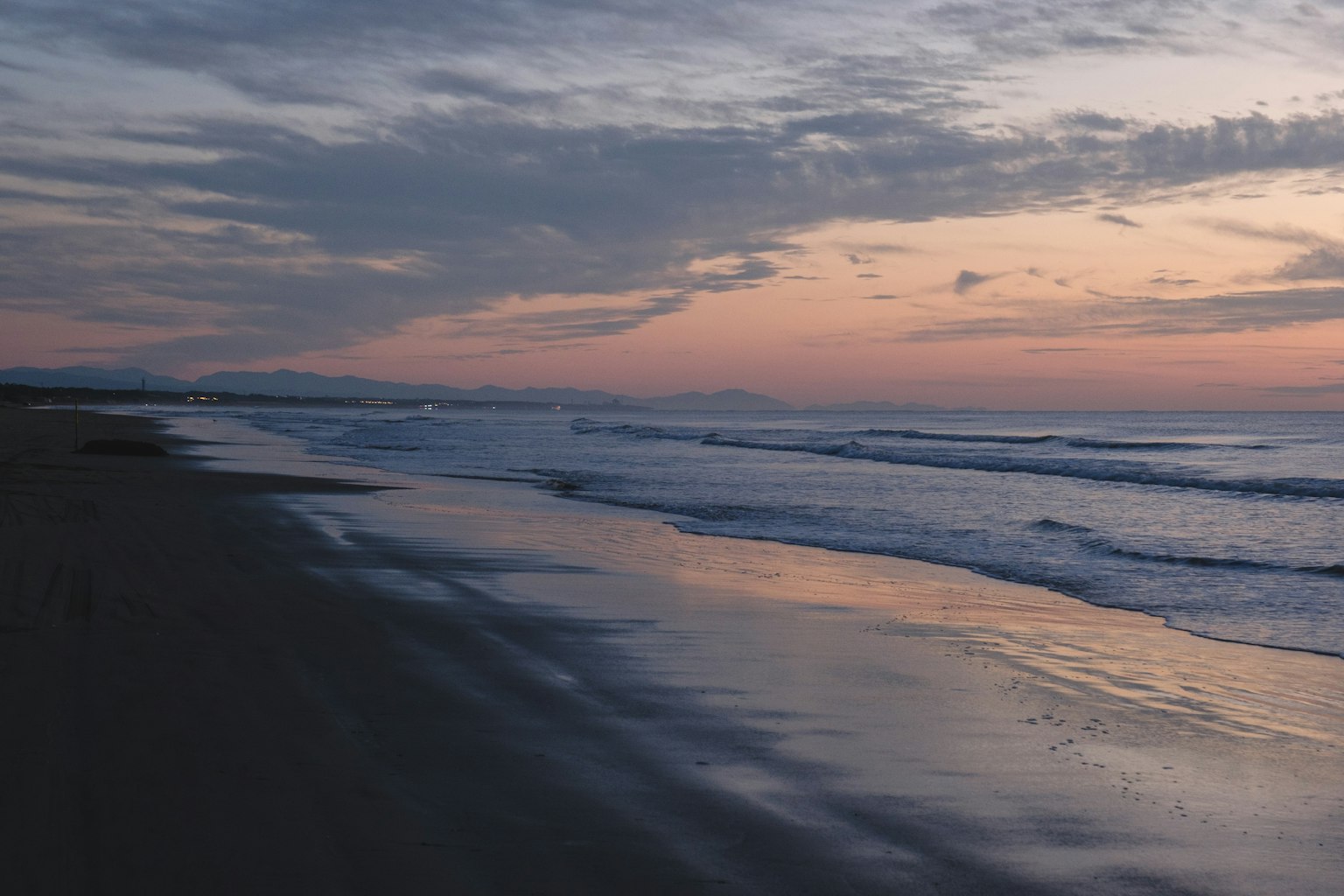 Ruhiger Strand bei Sonnenuntergang mit sanften Wellen