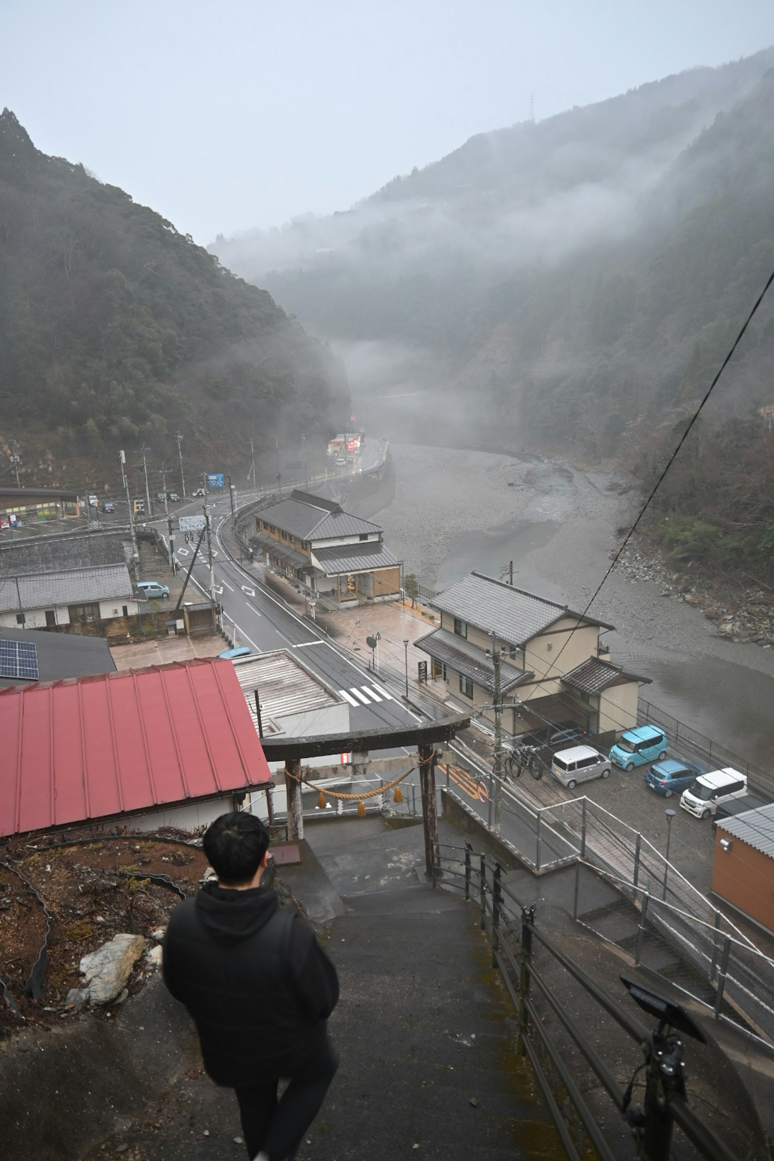 俯瞰雾气笼罩的山村与道路的人