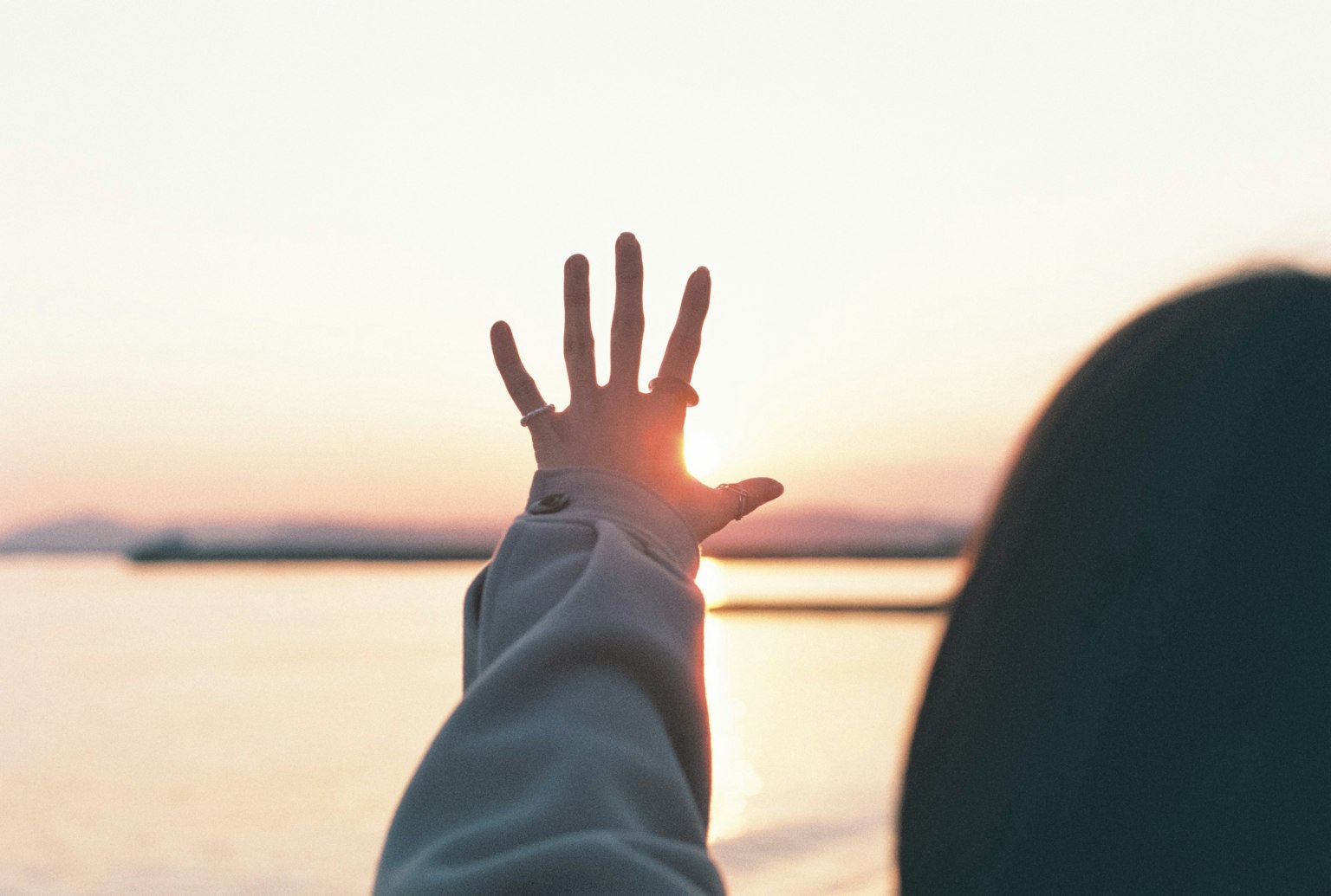 Silhouette di una persona che raggiunge il tramonto