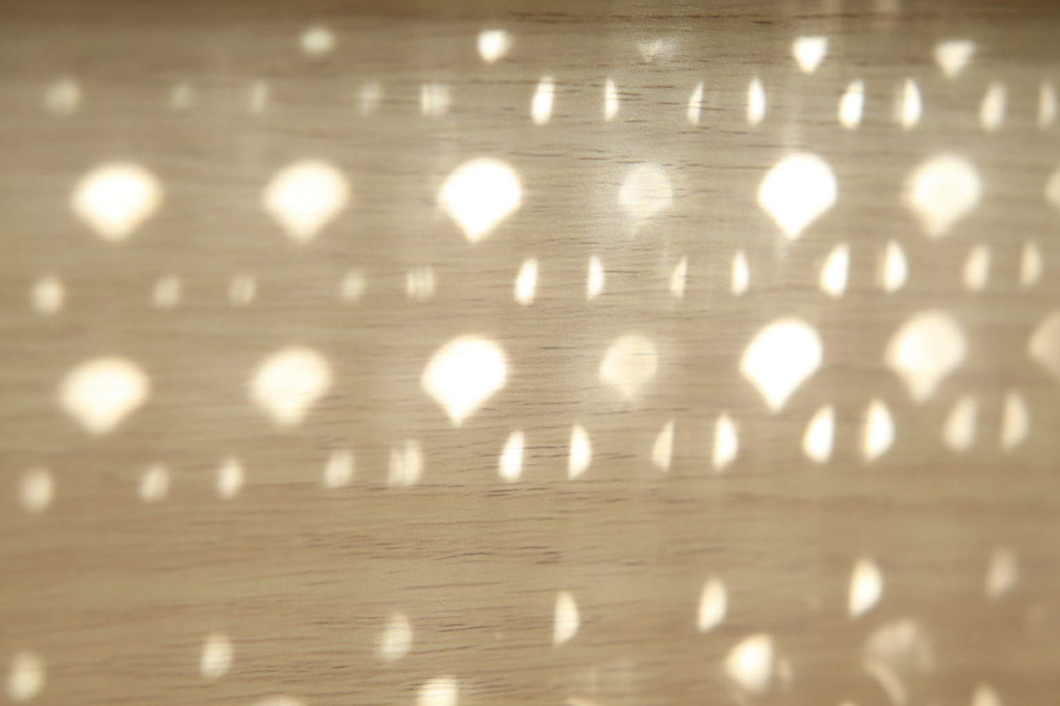 Soft light creates unique patterns on a wooden surface