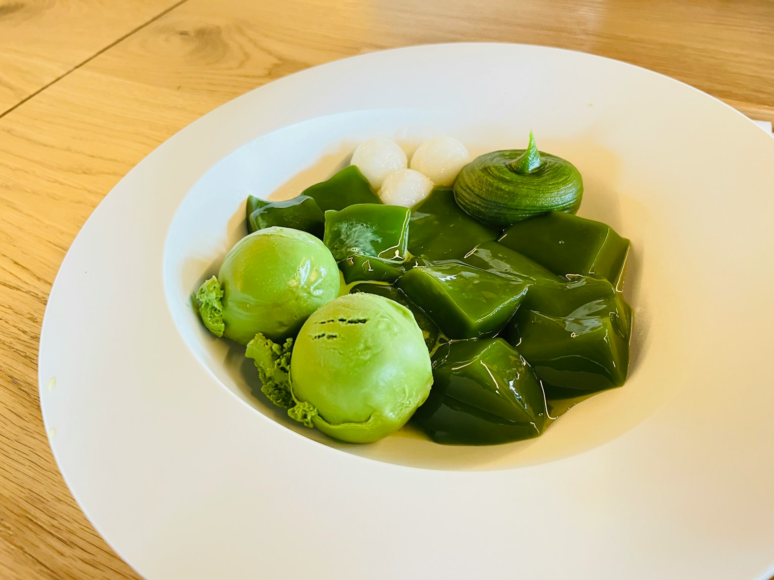 Un piatto con vari ingredienti verdi disposti artisticamente