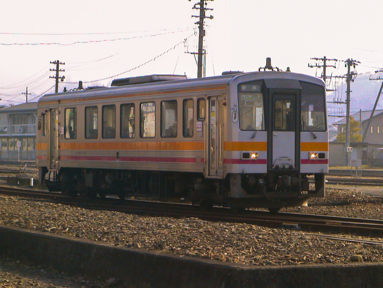 Un train japonais avec des rayures orange circulant sur les rails