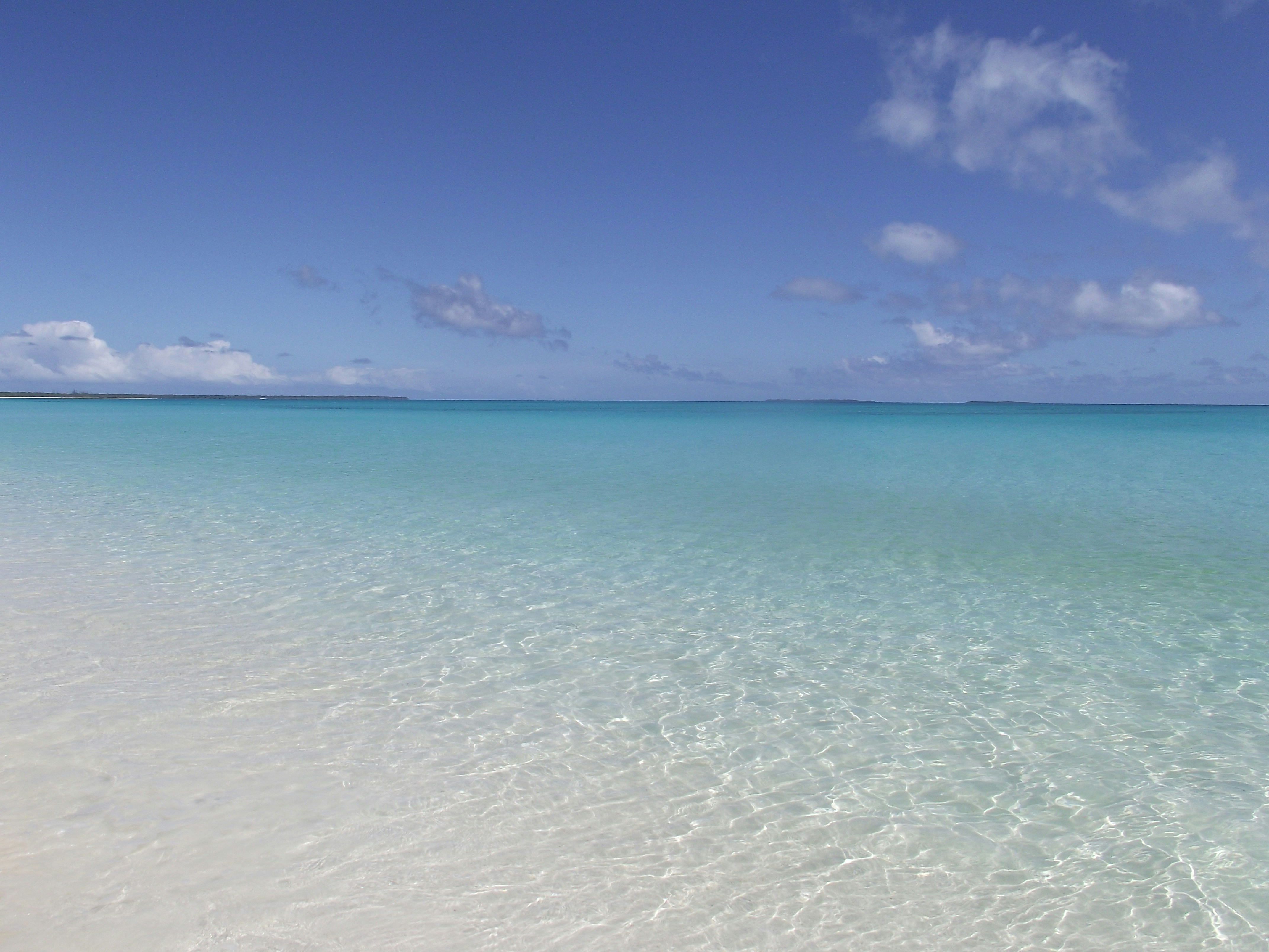 klare türkisfarbene Meeresoberfläche mit fernem Horizont unter blauem Himmel