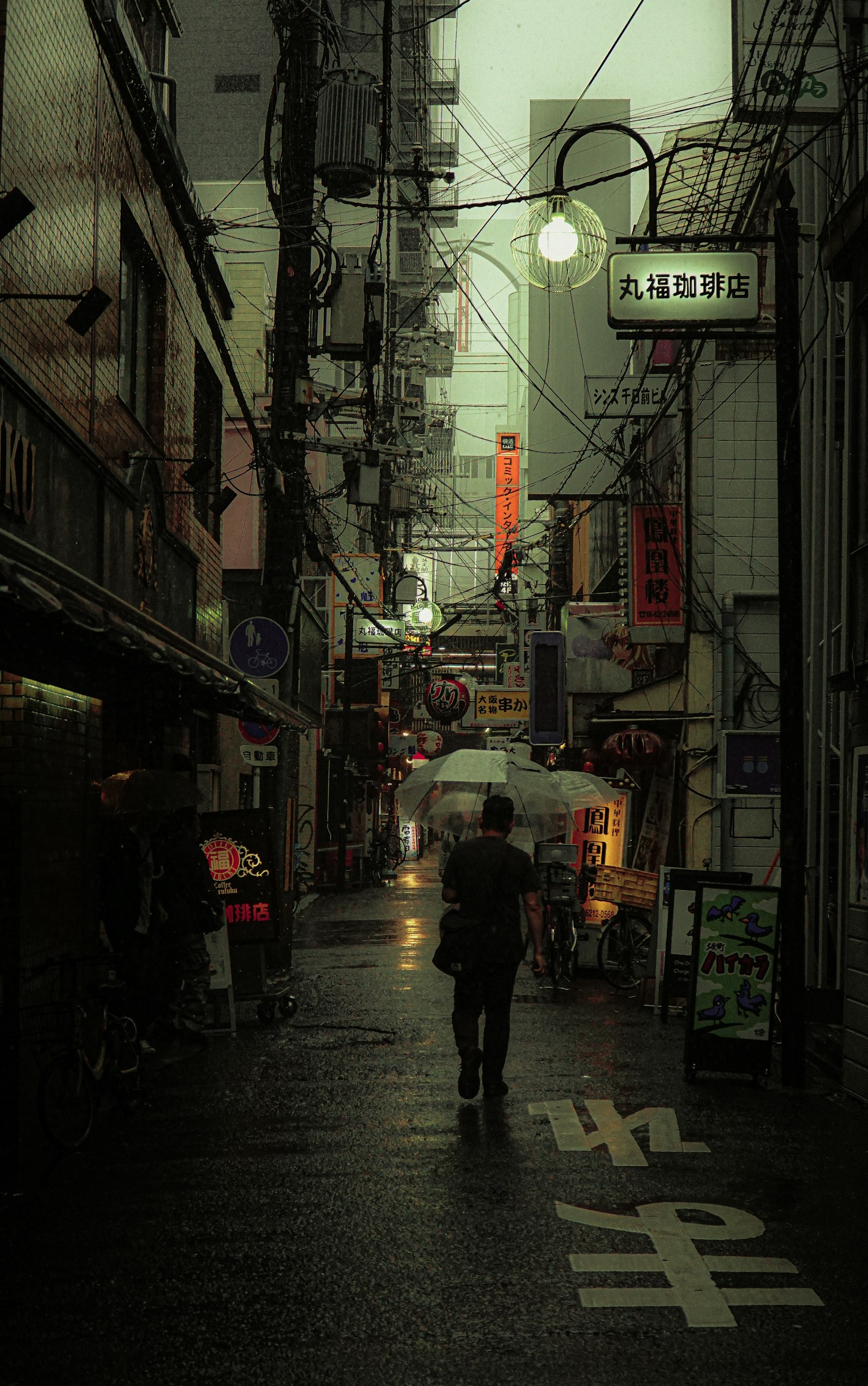 在昏暗小巷中行走的行人，街灯和雨水