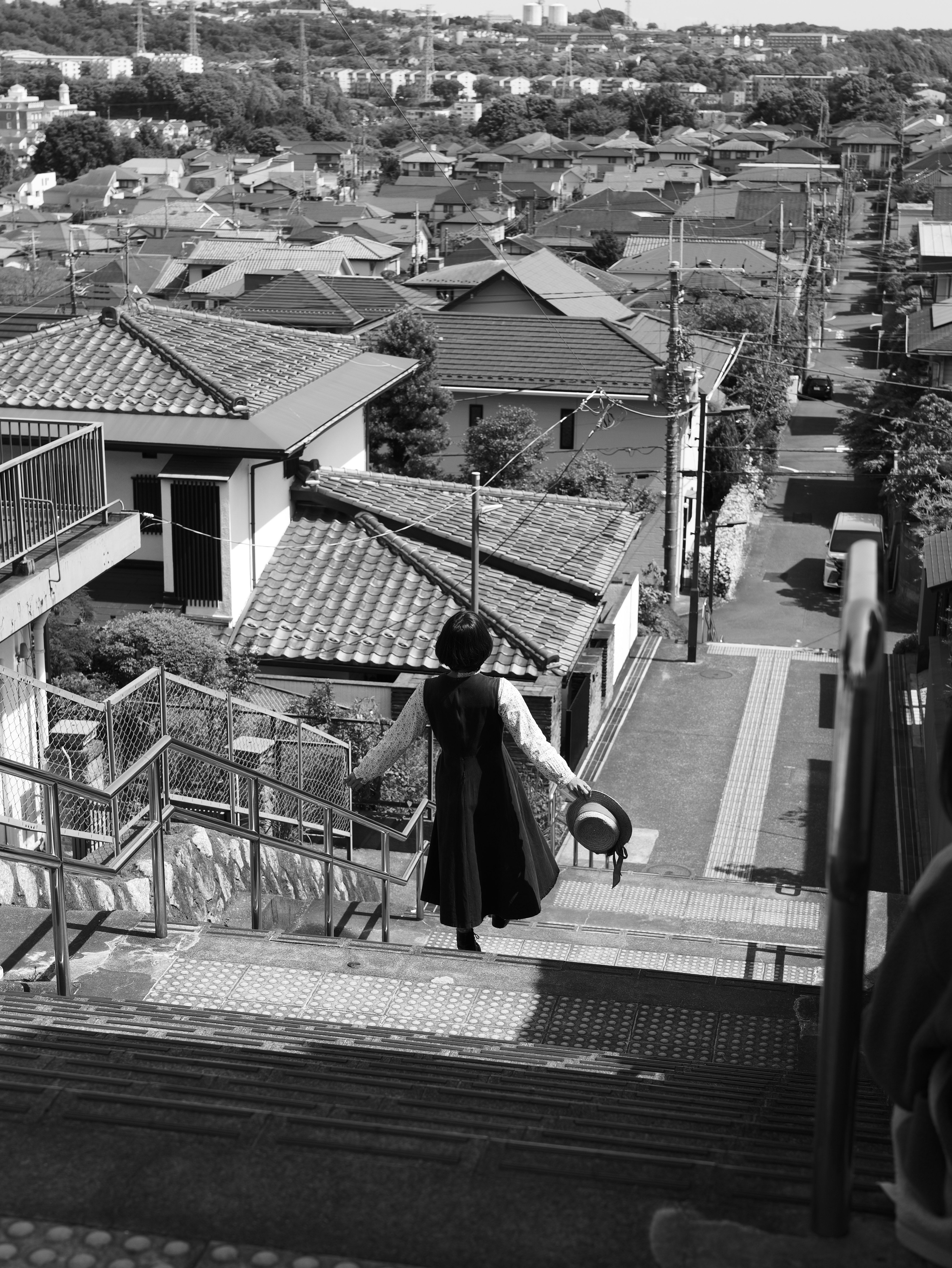persona che scende una scala con vista su un quartiere residenziale