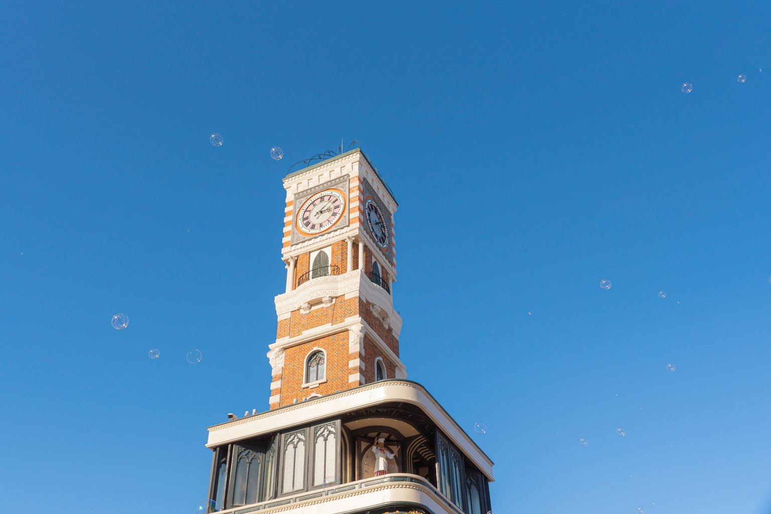 Parte superiore di una torre dell'orologio storica contro un cielo blu chiaro