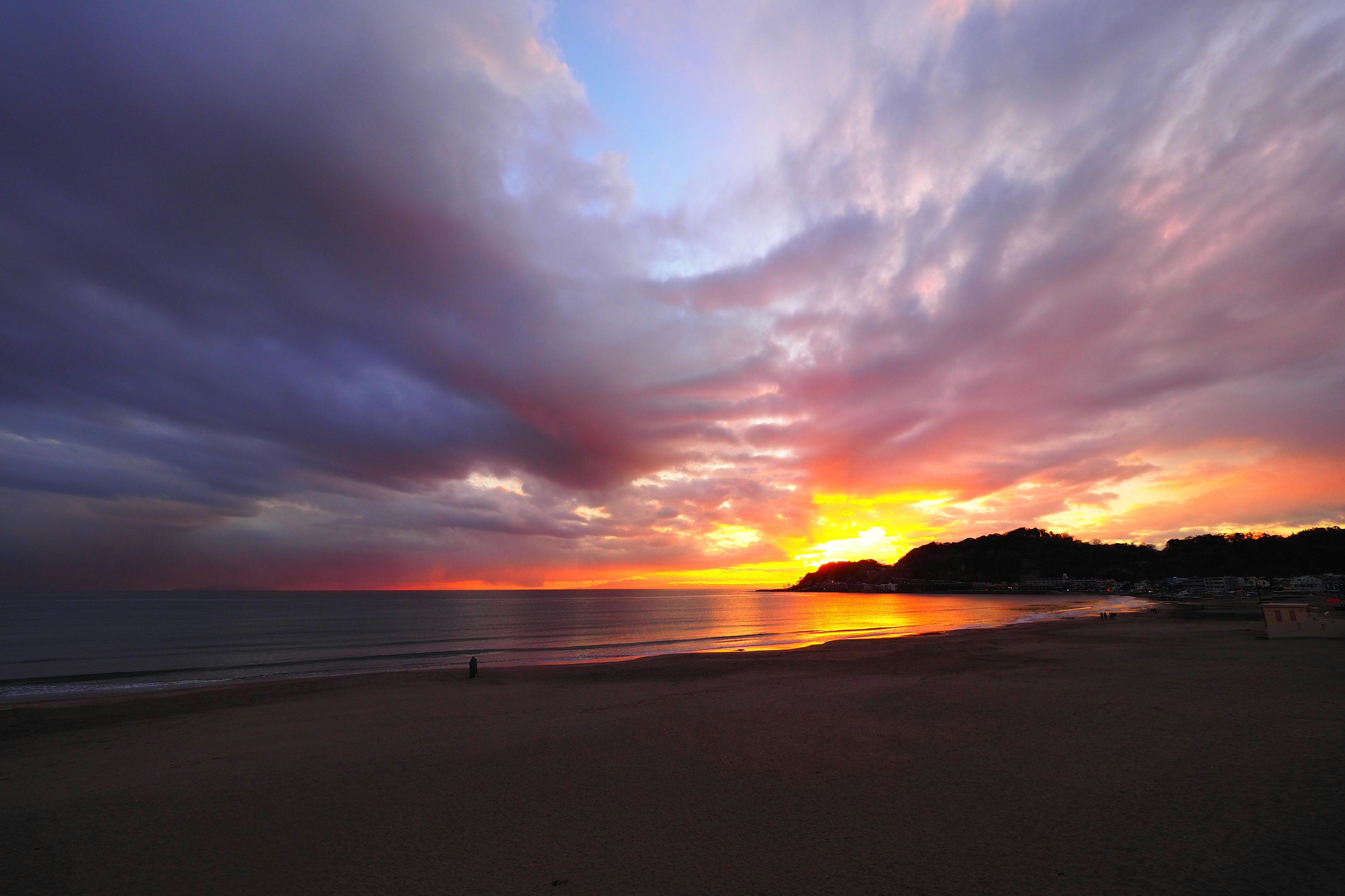 夕焼けの海辺と水平線のある砂浜の風景
