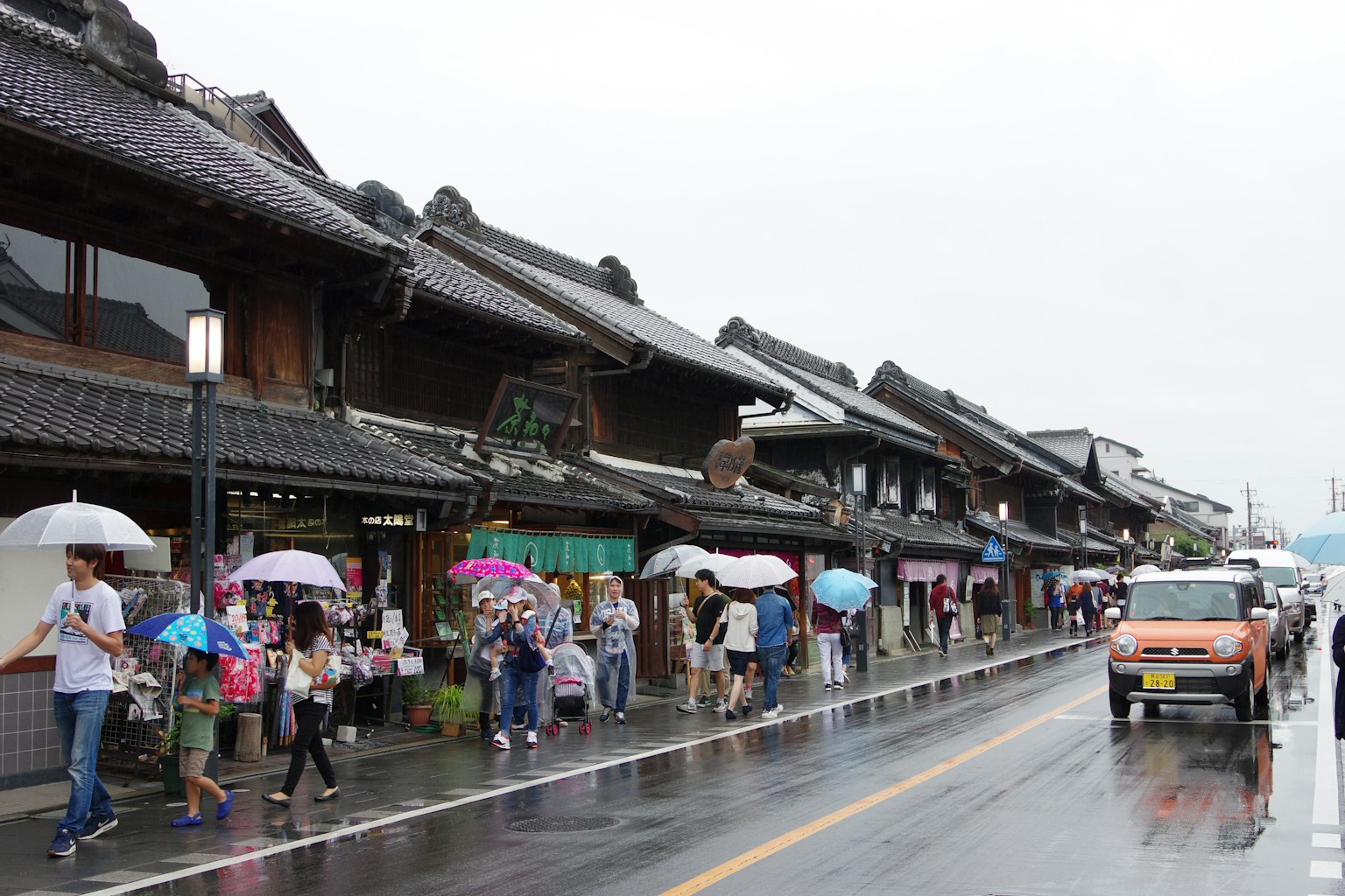 传统日本街道上的人们在雨中撑伞