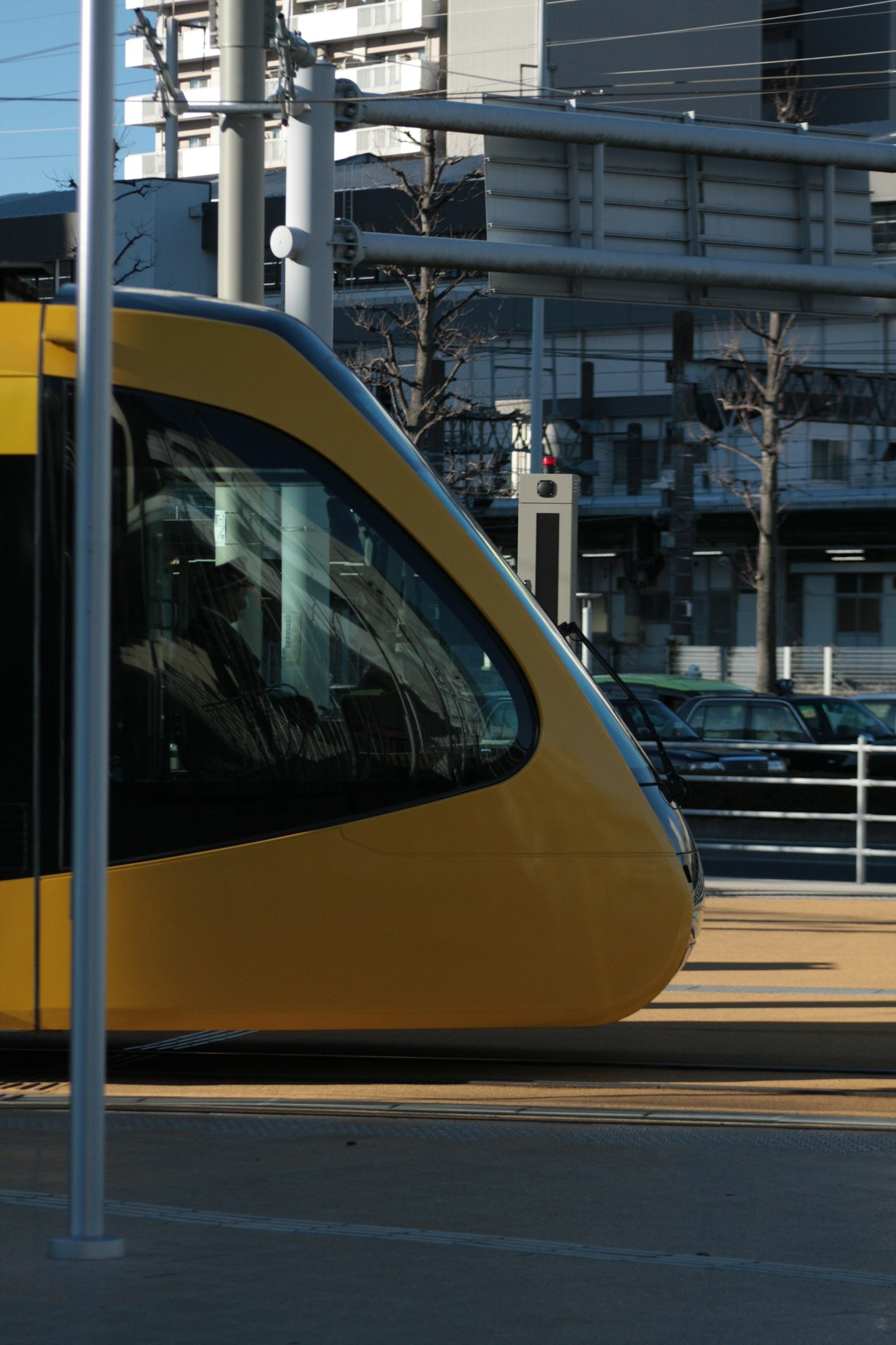 黃色電車的特寫，背景是城市建築