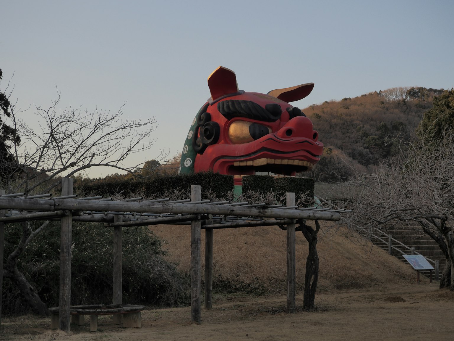 Foto di una grande scultura di leone rosso su sfondo collinare