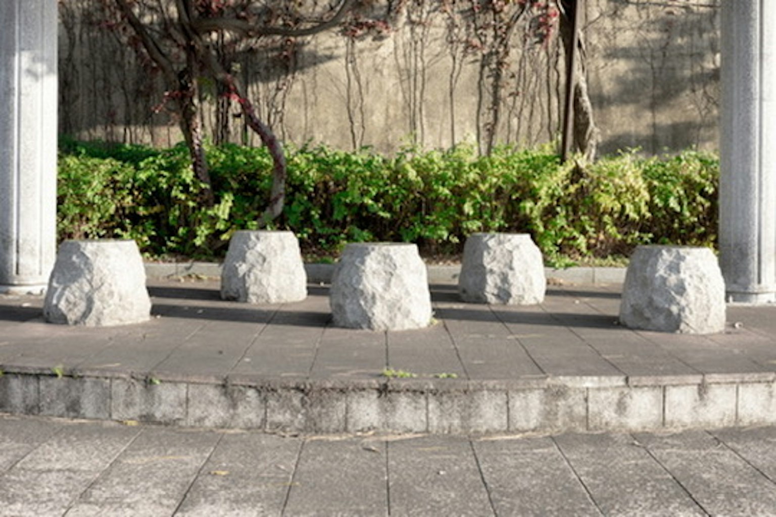Five stone benches arranged in a park setting