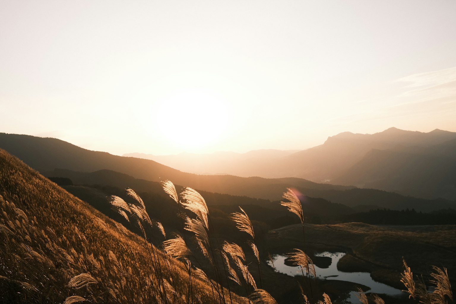 Landschaft mit Bergen und Feld bei Sonnenuntergang