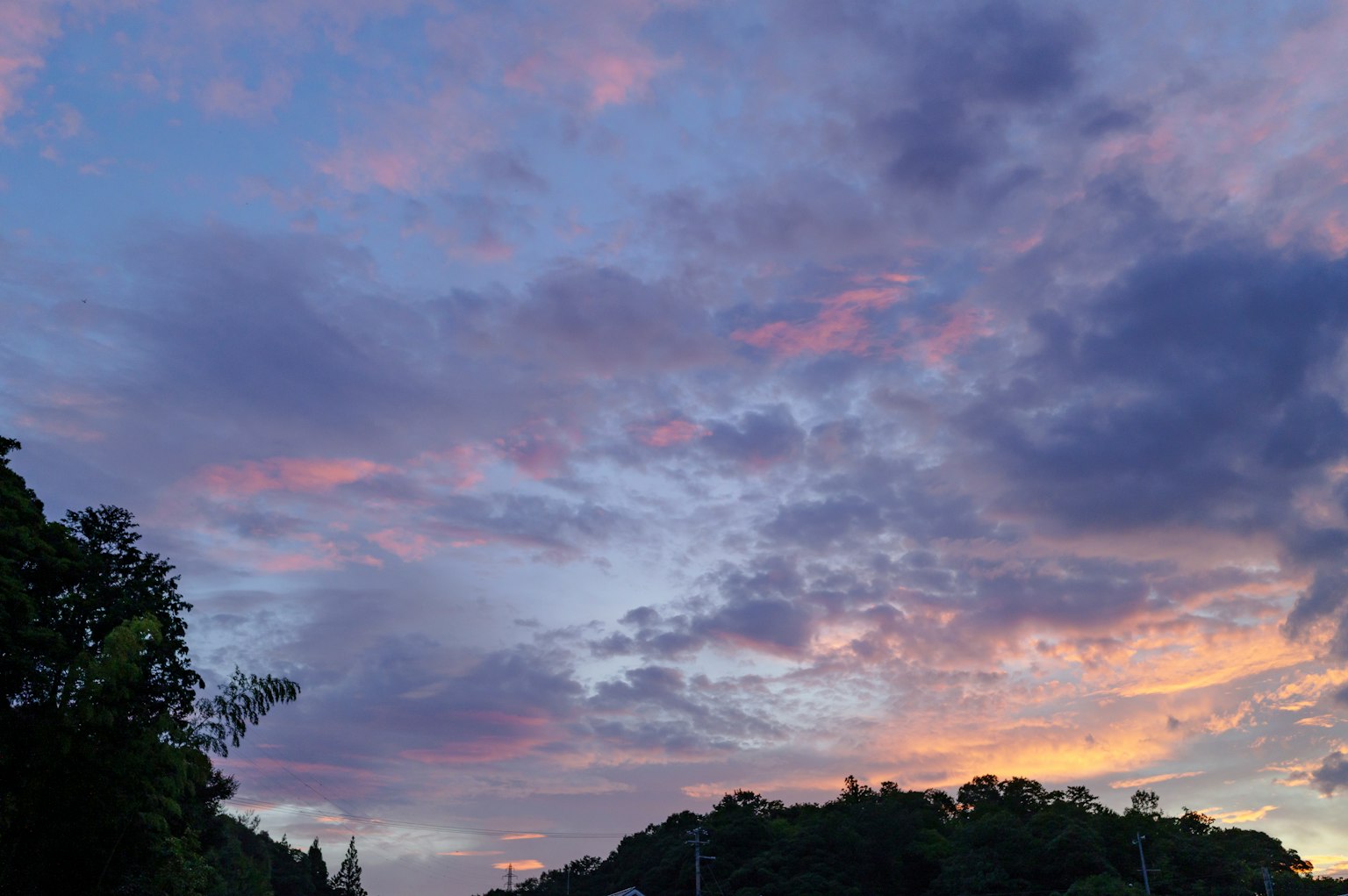 Un paysage de ciel au coucher de soleil avec des nuages violets et orange