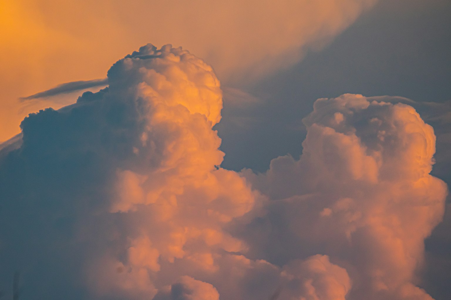 Ciel rempli de nuages orange et bleu au coucher du soleil